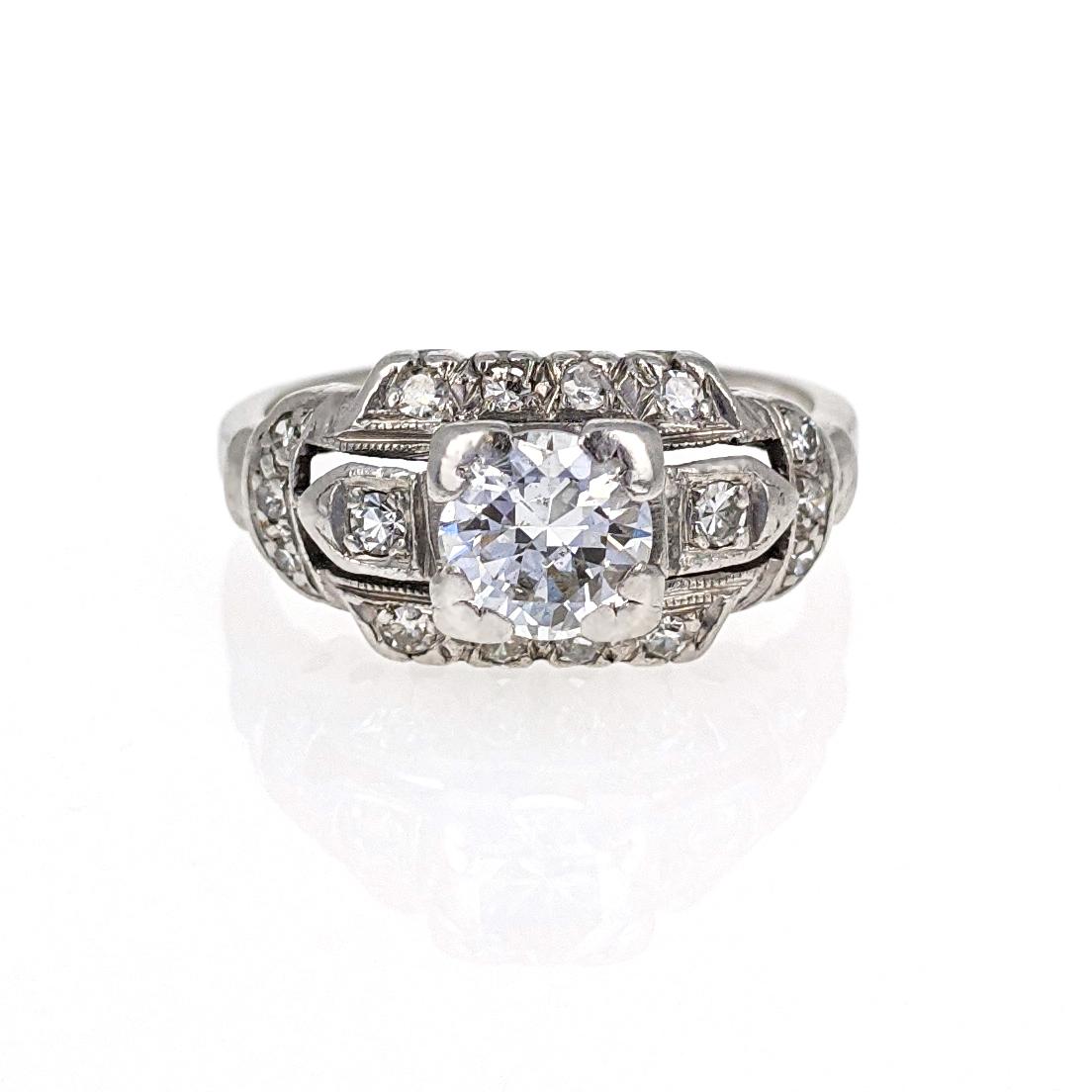 This beautiful Art Deco engagement ring features a round brilliant-cut diamond weighing approximately .75 carat with F-G color and SI clarity. It is accented by 16 single cut diamonds and artfully crafted in platinum with delicate millgrain