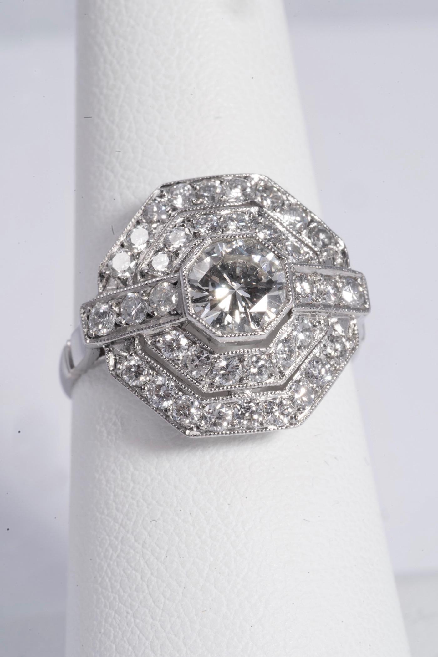 Gorgeous Art Deco Style diamond ring. The center diamond is a round brilliant cut, weighs approximately .65cts and has F-G color and VS2 Clarity. There are 36 round brilliant cut diamonds surrounding the center diamond. They each weigh approximately