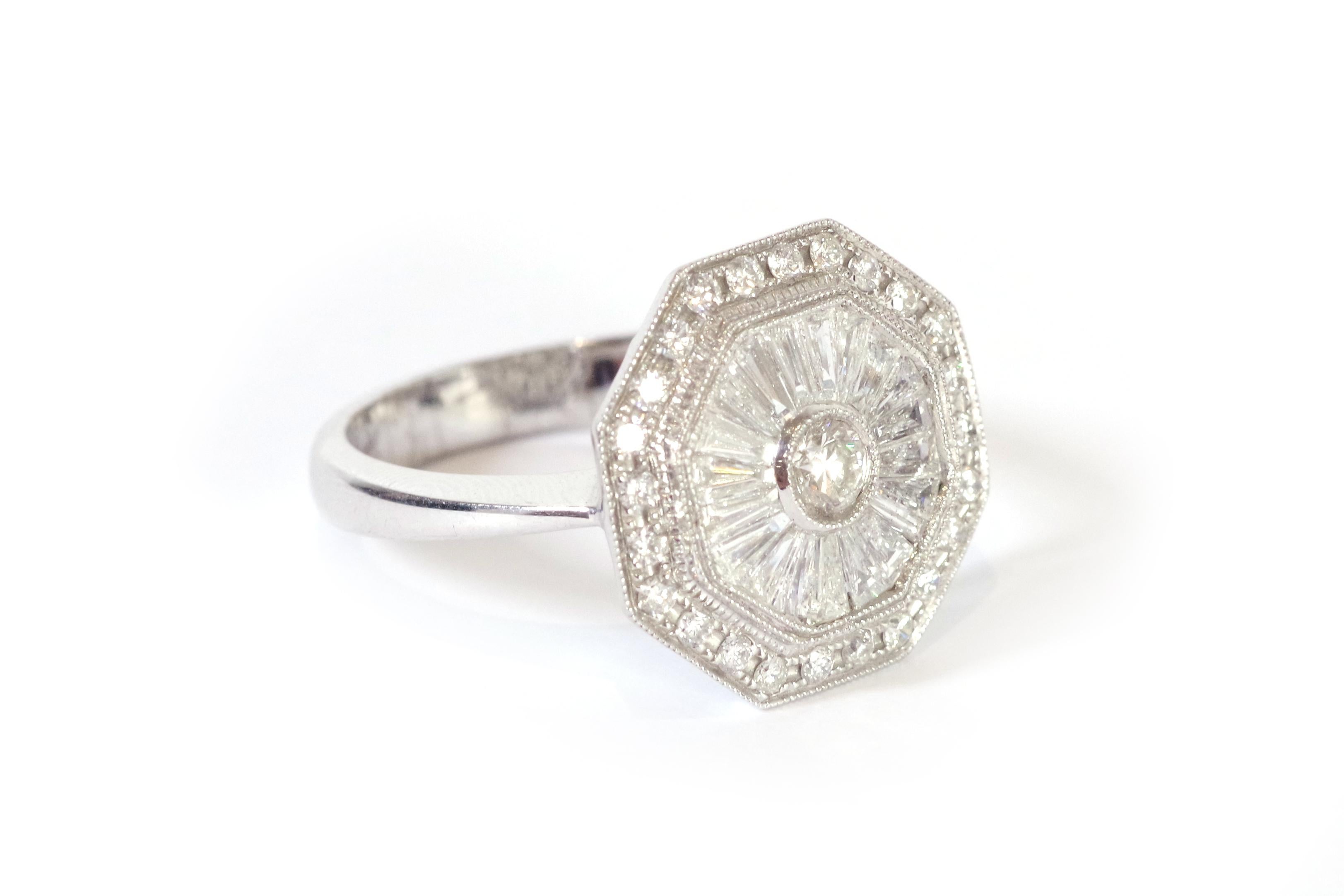 Diamantring im Art-Déco-Stil aus 18 Karat Weißgold. Achteckiger Ring, vollständig mit Diamanten besetzt. Der zentrale Diamant im Brillantschliff von etwa 0,20 Karat ist in einer Perlenfassung gefasst. Der Hauptdiamant ist von 20 Diamanten im