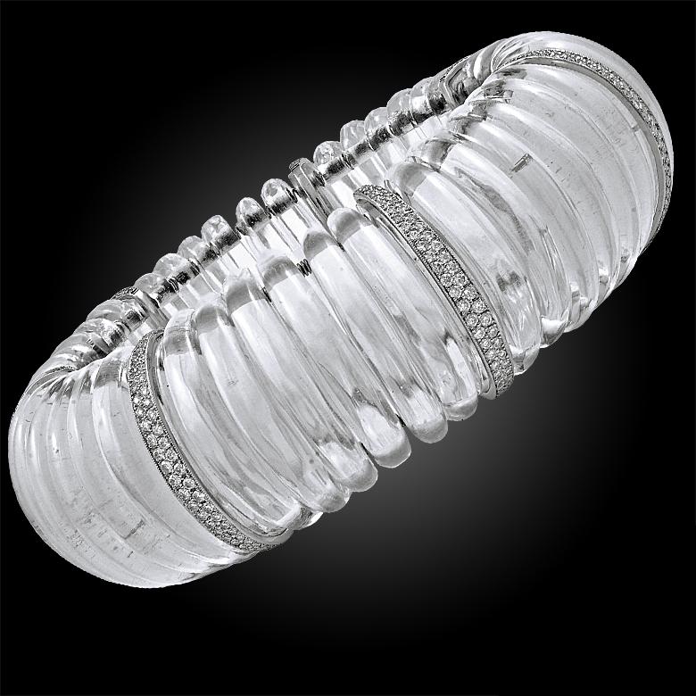 A stylish Art Deco bangle, transitional from day to night, designed with a series of rock crystal and brilliant cut diamonds, crafted in platinum gold.
