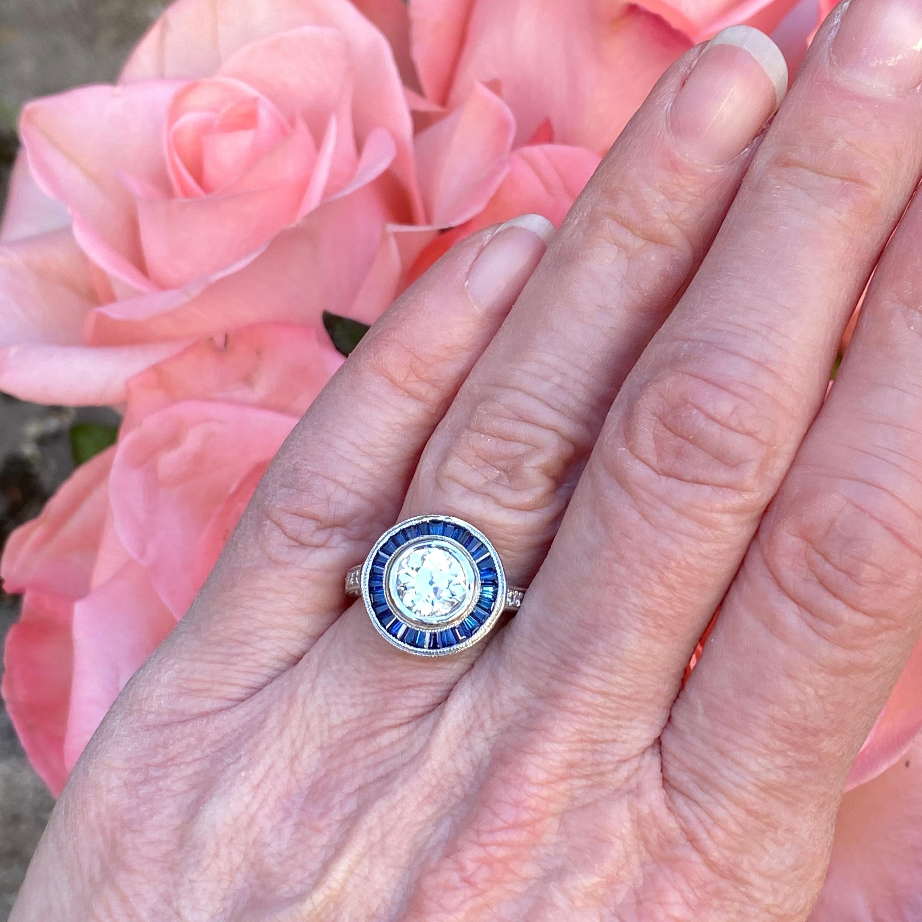 Details:
Stunning vintage Art Deco style diamond & sapphire engagement ring. The band is platinum. This is an gorgeous ring with lovely engraving around the shoulders of the band, and has engraving details surrounding the diamond. This ring is