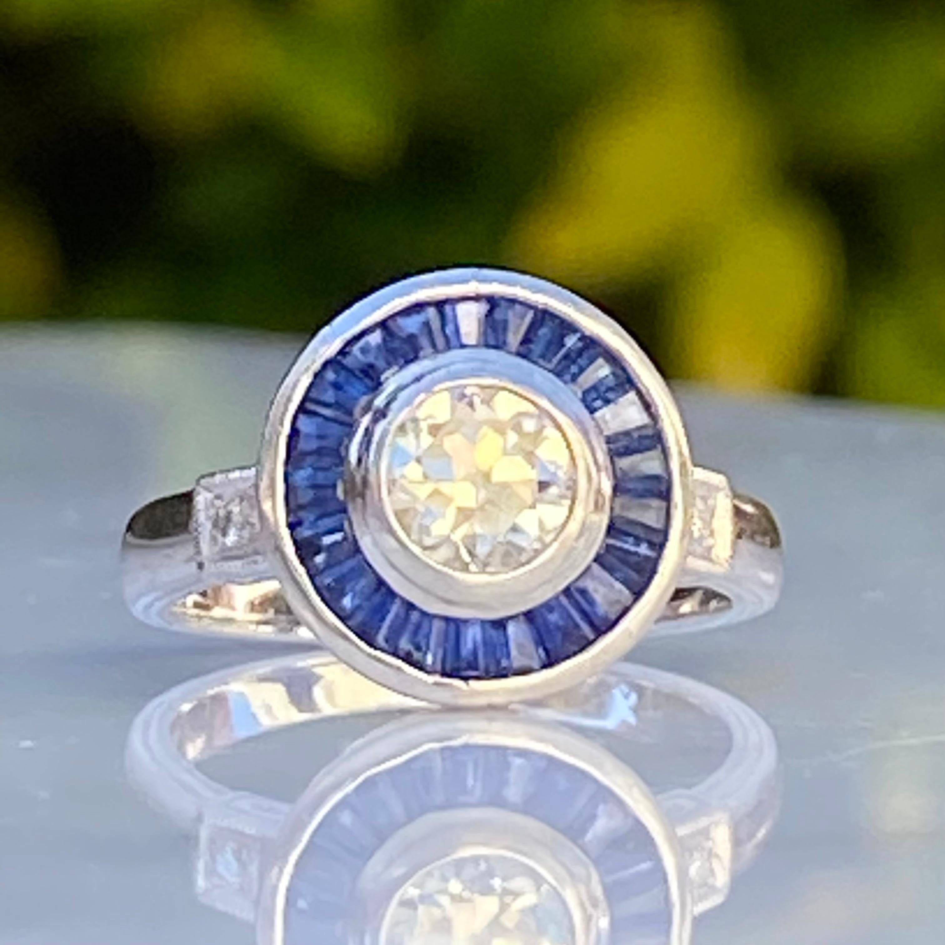 Details:
Stunning vintage Art Deco style .73 carat Old European Cut diamond & 1 carat sapphire engagement ring. The band is platinum. This is a gorgeous ring with lovely engraving around the shoulders of the band, and has engraving details