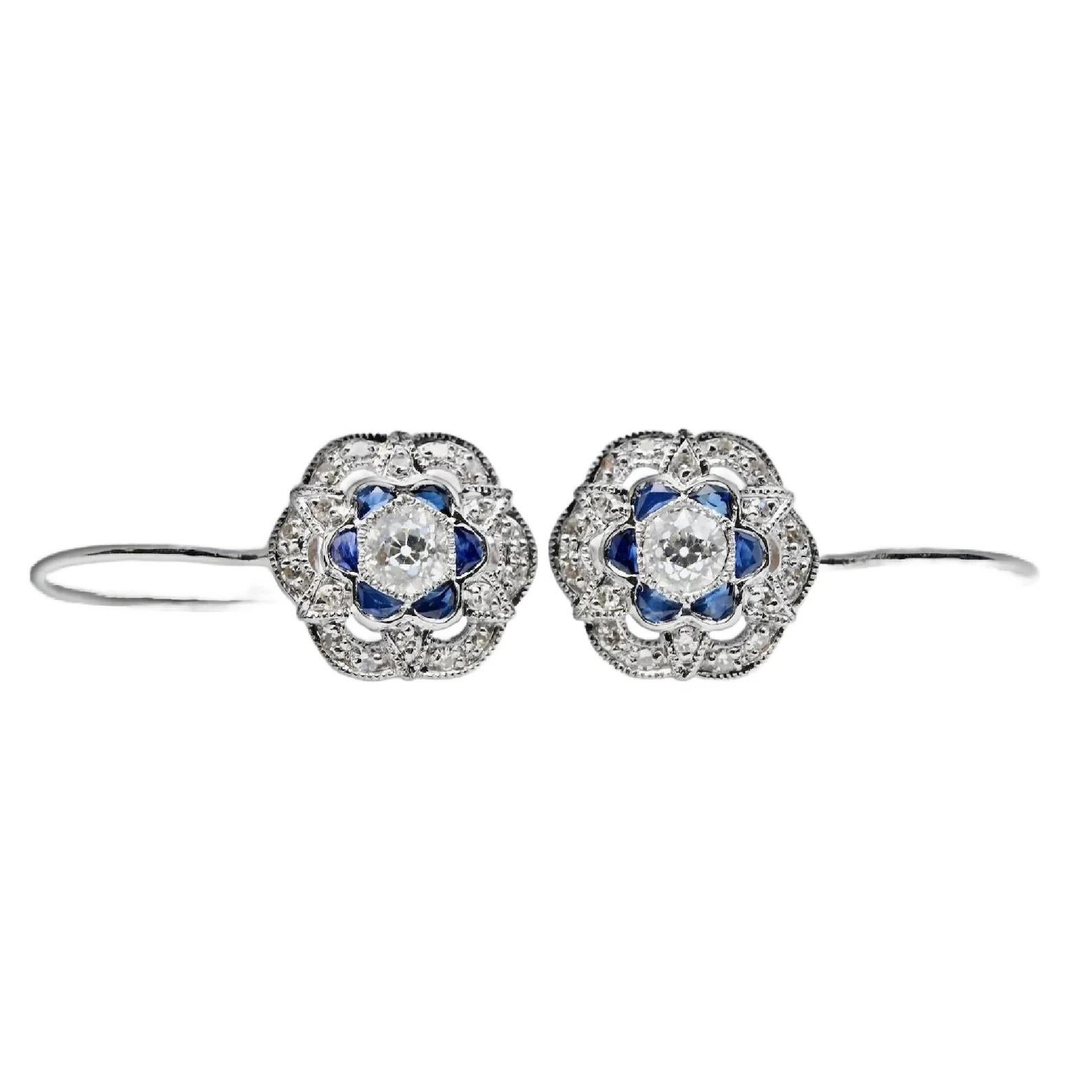 A pair of handmade Art Deco style diamond and sapphire earrings. Crafted in 14 karat white gold these earrings are centered by old European cut diamonds. Framing the center diamonds are custom half moon cut sapphires and pave set round accent