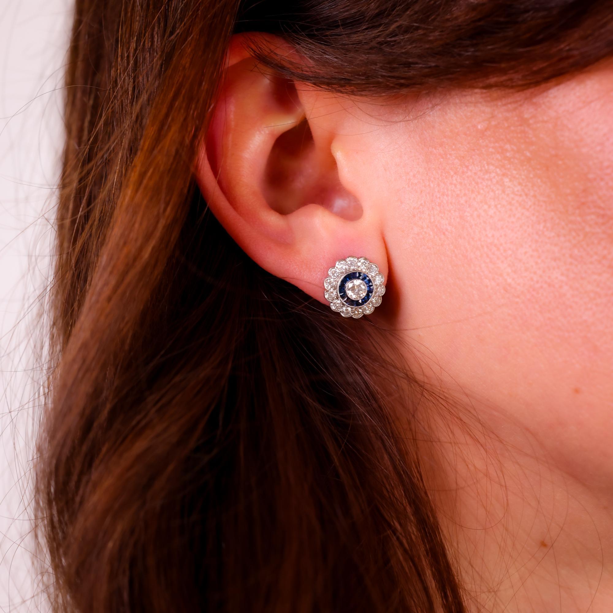 Questi orecchini in platino in stile Art Deco degli anni '90 sono caratterizzati da diamanti abbaglianti e zaffiri blu profondo taglio calibro, creando una dichiarazione elegante e senza tempo.

Pietra centrale: 2 diamanti rotondi taglio