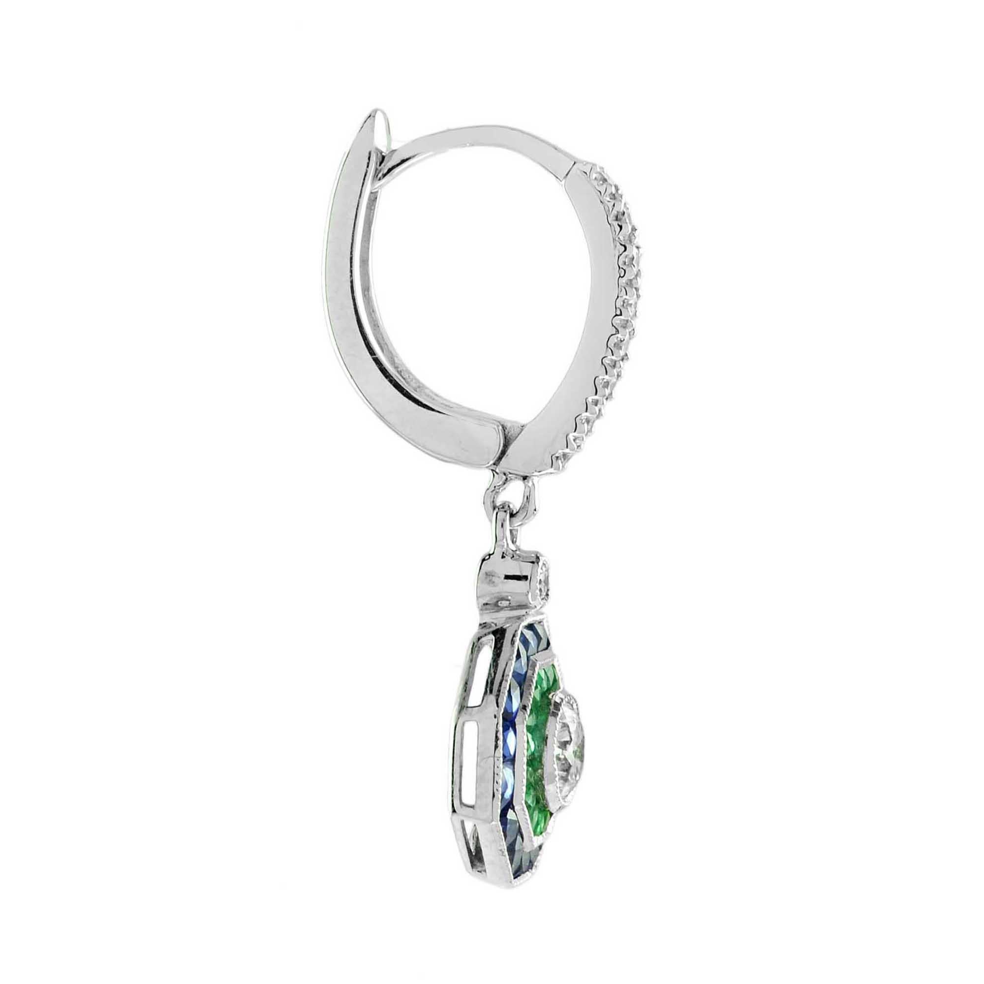 Exquisite early Art Deco inspired Diamond and Emerald earrings. The central Diamond is surrounded by finely set emeralds and sapphires to an outer creating a chic octagonal form. The earrings are perfectly worn with the same design halo ring. 14K