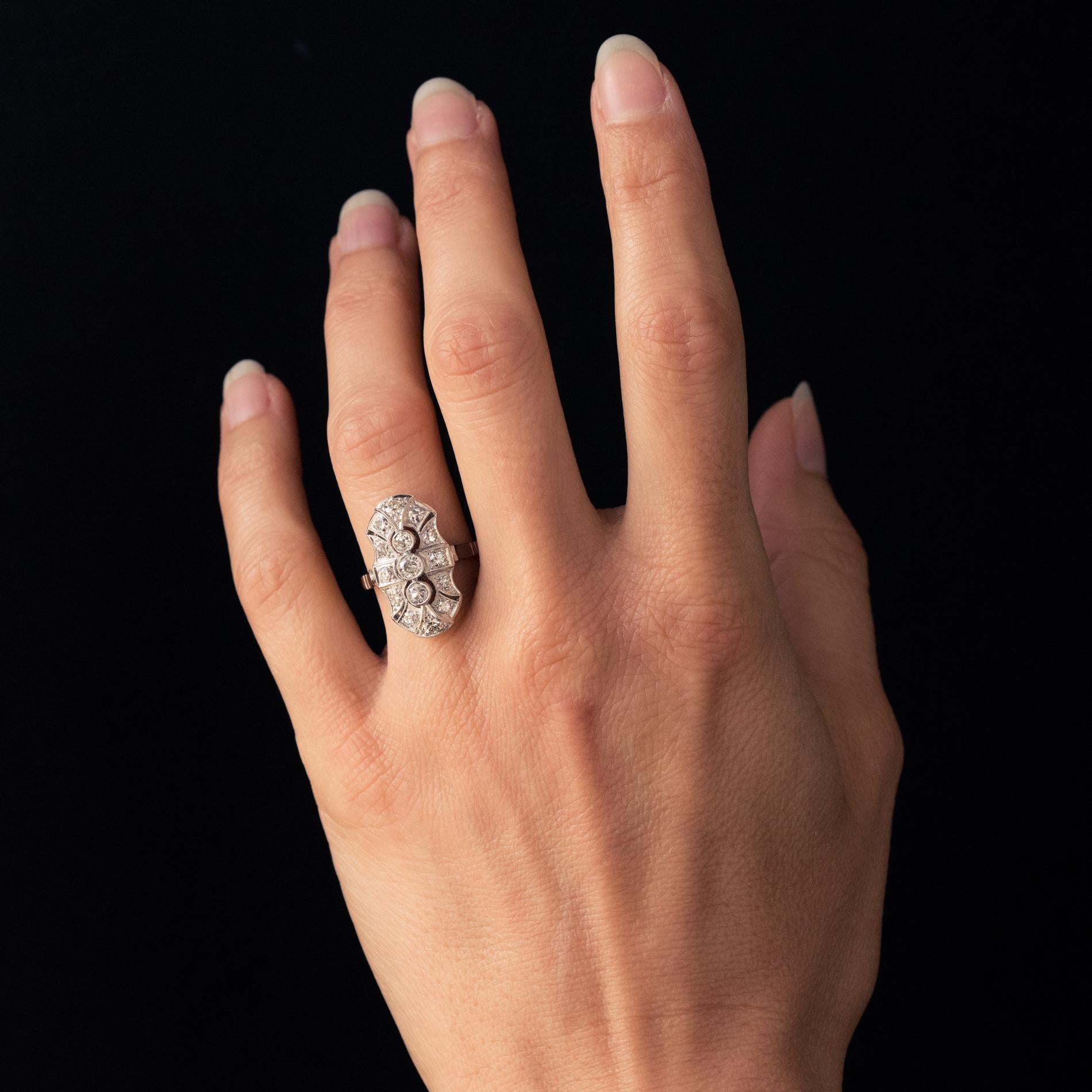 Ring aus 18 Karat Weißgold, Eulenpunze.
Inspiriert von den Linien und Techniken des Art Déco, ist dieser reizvolle Ring mit 3 Brillanten in einer durchbrochenen, ziselierten und eleganten Verzierung in Millegrain-Fassung besetzt. Die Fassung ist