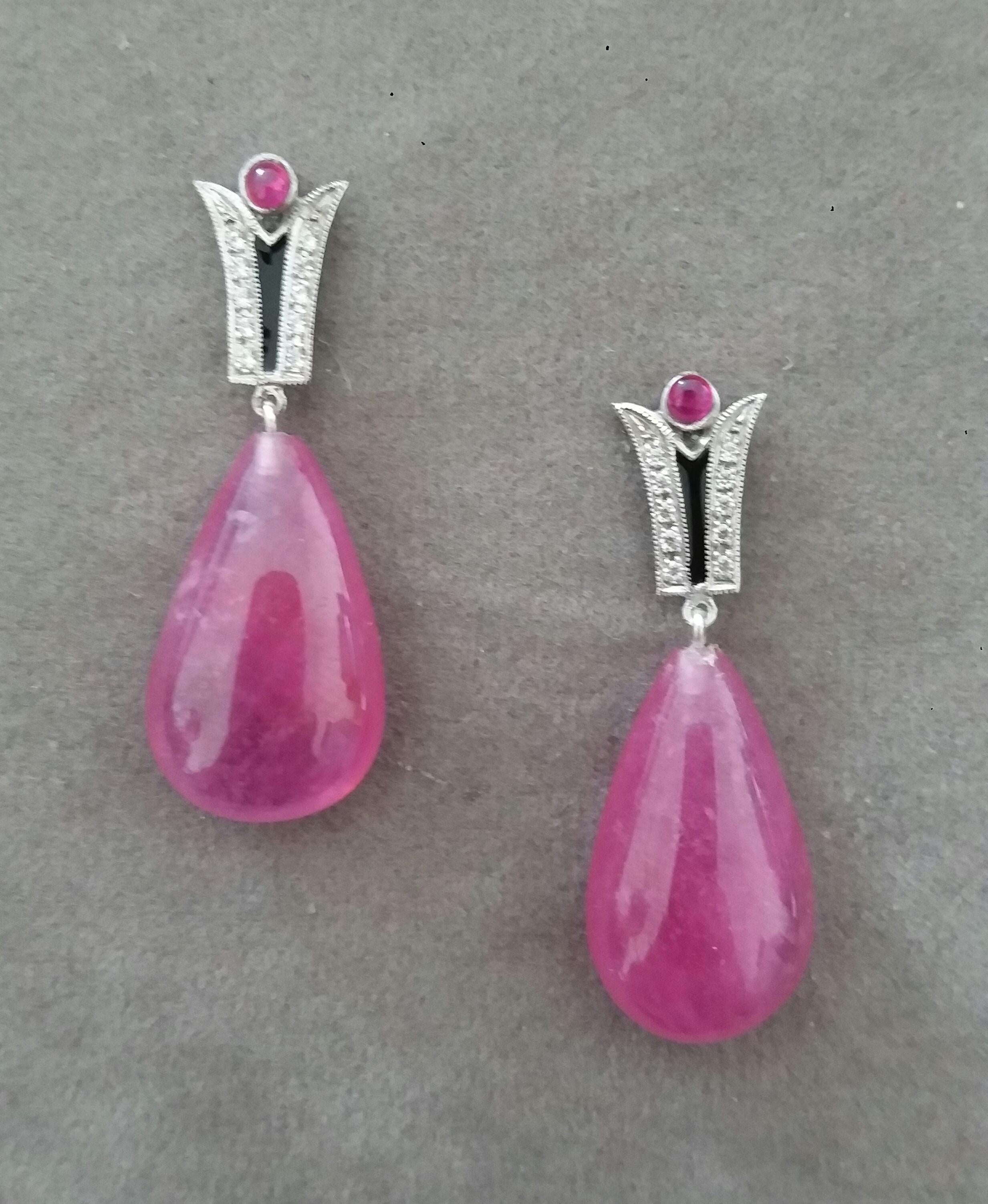 In questi orecchini classici in stile Art Déco, le parti superiori sono costituite da due elementi  in oro bianco 14 kt., 20 diamanti rotondi a taglio pieno, smalto nero e piccoli rubini rotondi cabochon, nella parte inferiore sono presenti 2