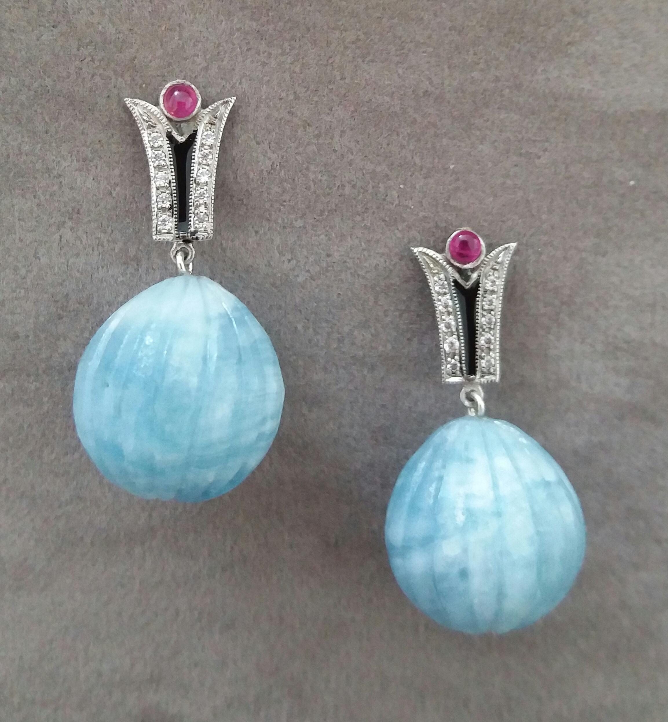 In these classic Art Deco Style earrings the tops are 2 elements  in 14 kt. white gold, 20 round full cut diamonds,black enamel and small round Ruby cabochons ,in the lower parts we have 2  Aquamarine  Carved Drops  measuring 15 x 15 mm and weighing