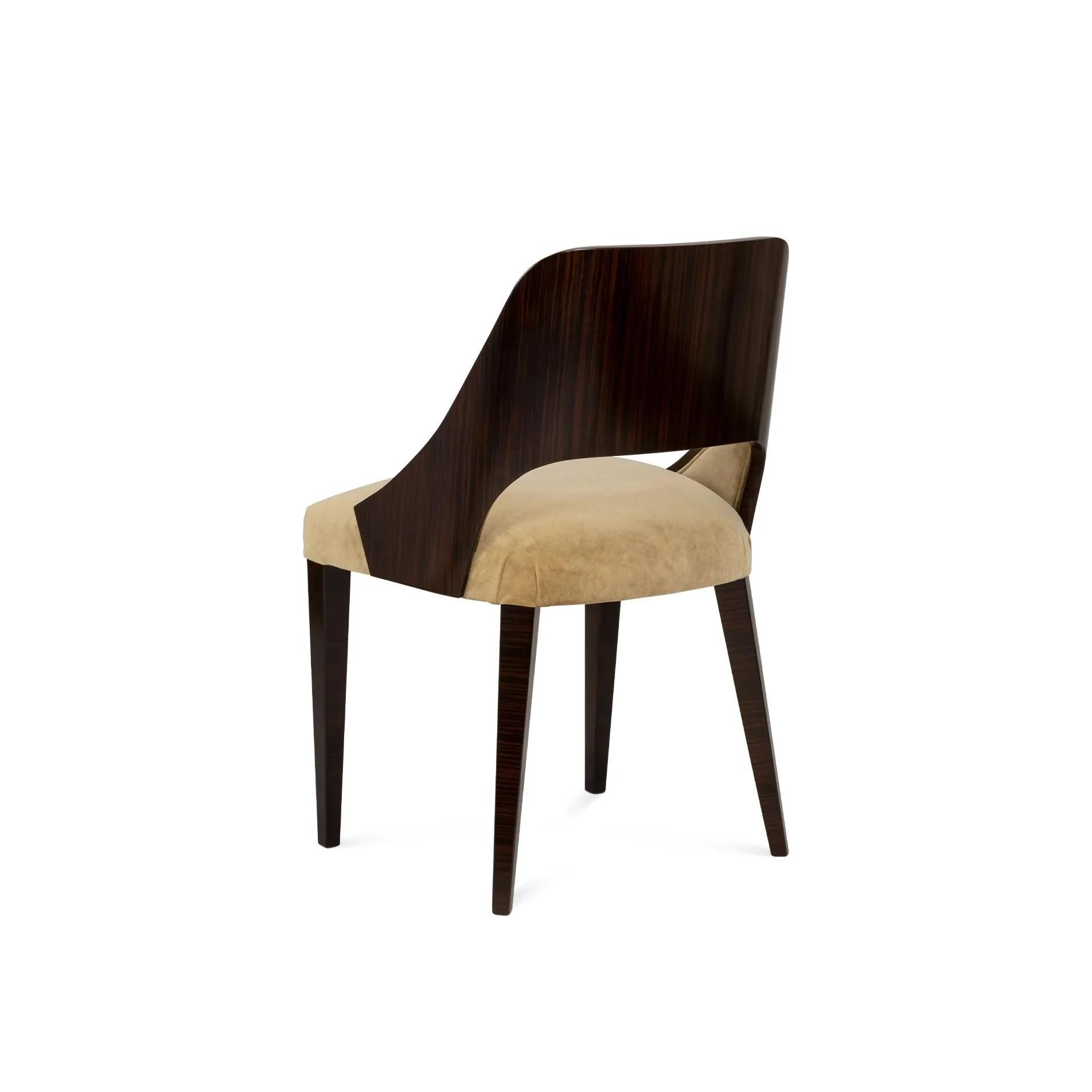 Dieser gepolsterte Sessel bietet Komfort und Klasse. Er verbindet plüschigen Samt mit einem eleganten Rahmen aus Ebenholz. Die dunklen Holzbeine, die wie robuste Säulen wirken, tragen eine Sitzfläche, die zu langen Gesprächen einlädt. Ein zeitloses