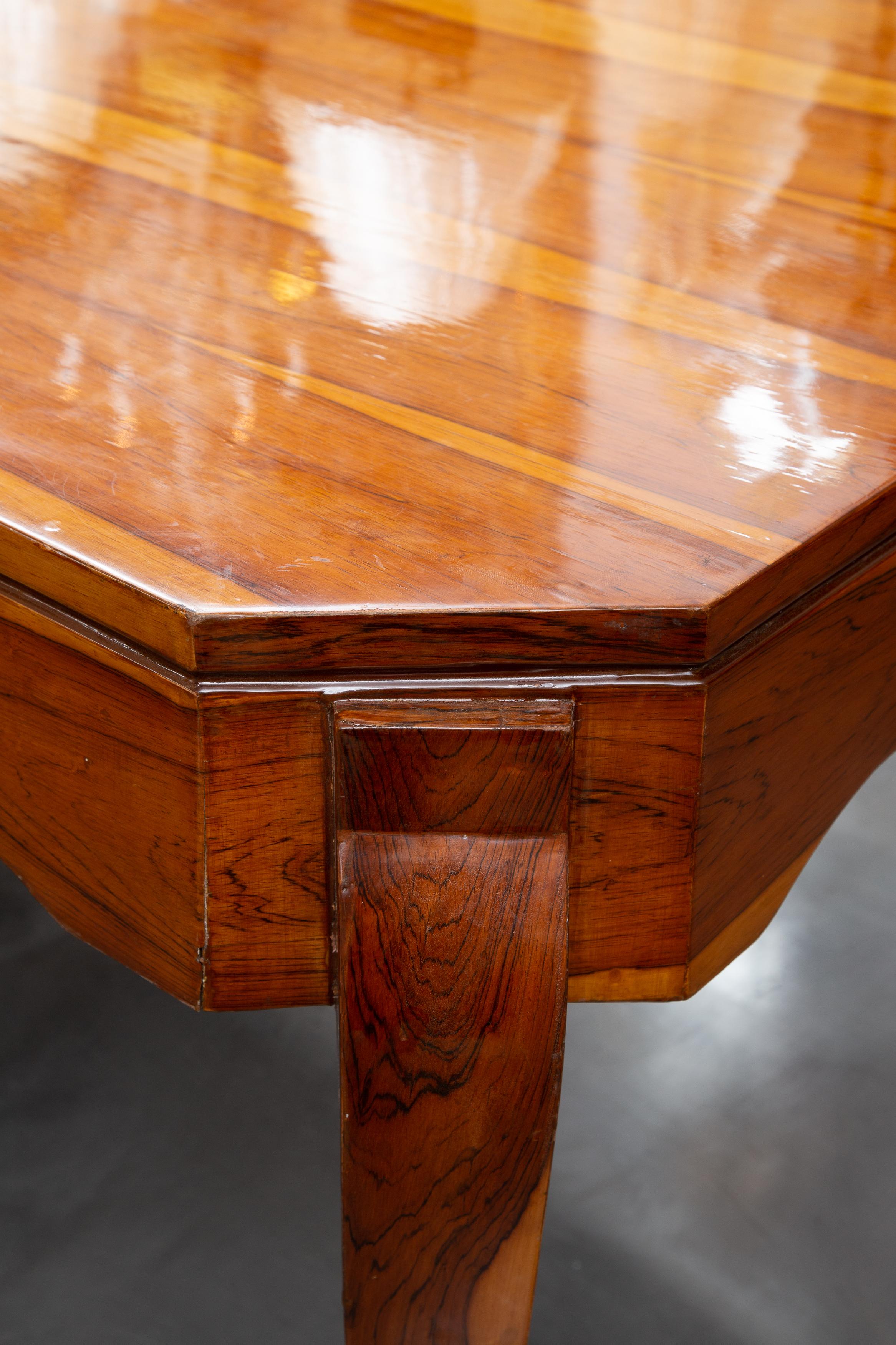 This is a unique Deco style dining table, made of an exotic wood and highly French polished. The top with straight edge is over a wide shaped frieze and raised on slightly curved legs.