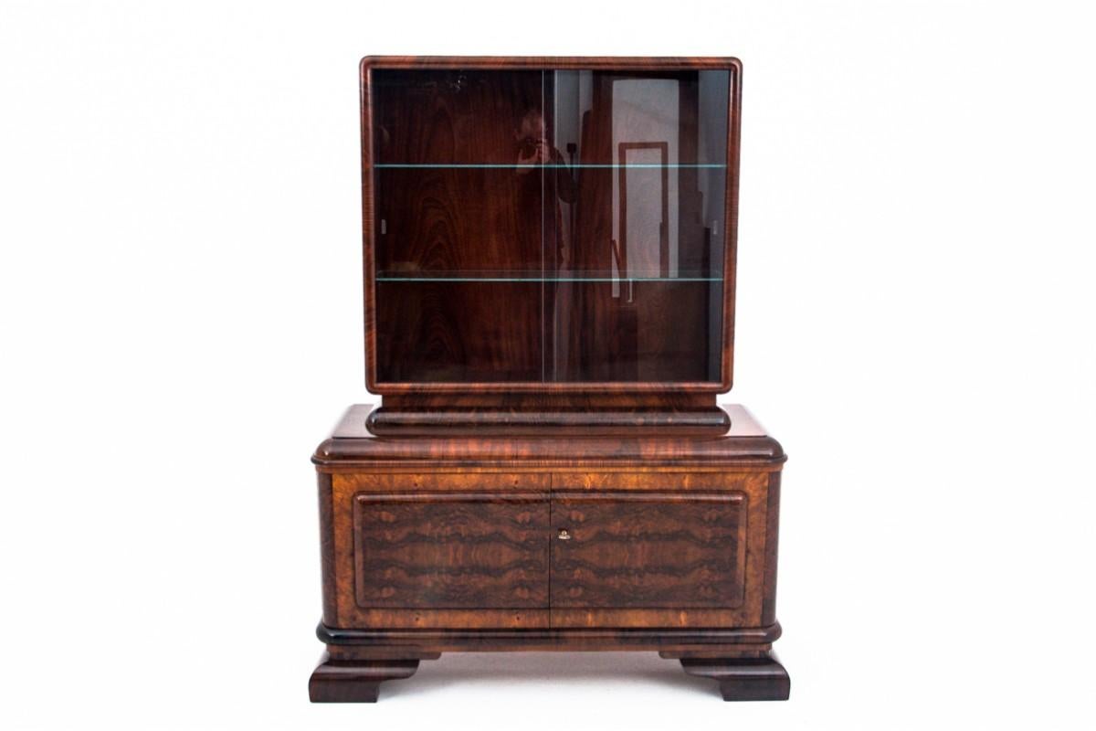 Art Deco display cabinet from the 1940s.

The furniture is in very good condition, after professional renovation. The display case is finished with high gloss polish.

Dimensions: height 178 cm / width 132 cm / depth 52 cm