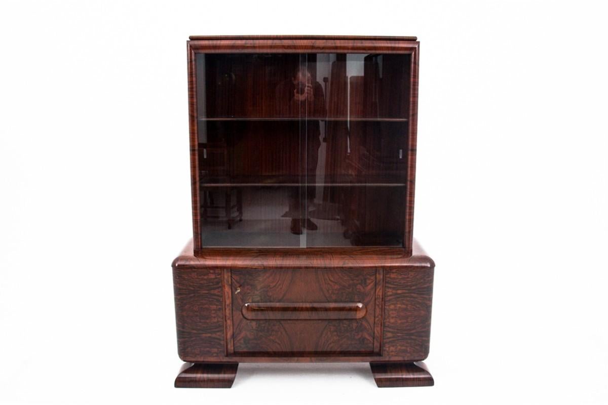Art Deco display cabinet from the 1940s.

The furniture is in very good condition, after professional renovation. The display case has a high-gloss polish finish.

Dimensions: height 167 cm / width 125 cm / depth 41 cm
