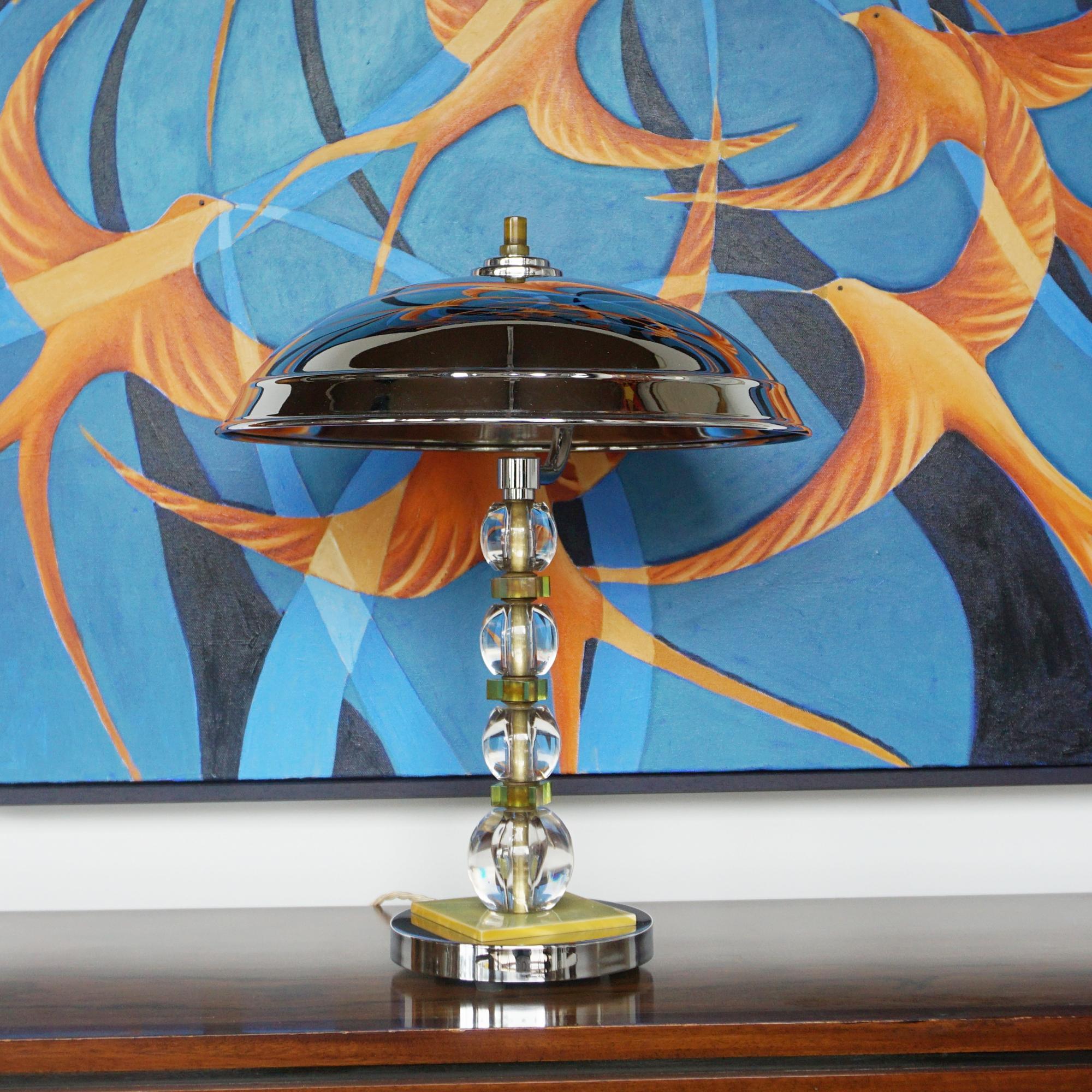 Lampe à dôme de style Art déco. Bakélite verte translucide  et tige en métal chromé avec un abat-jour en métal chromé en forme de champignon et un embout en bakélite au sommet.

Dimensions : H 43cm D 35cm

Origine : Anglais

Numéro d'article :