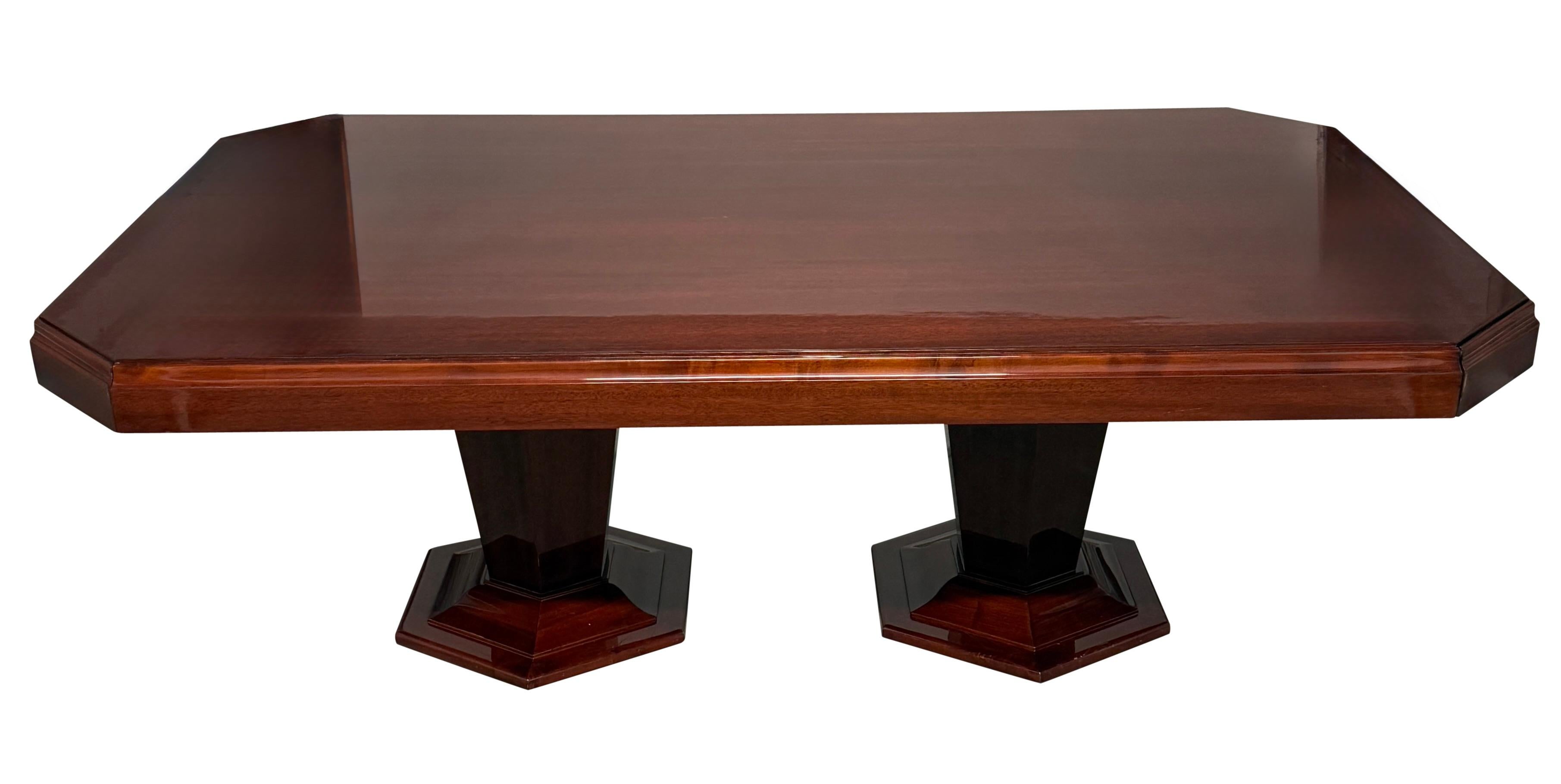 Table de salle à manger à deux pieds de style Art déco, fabriquée sur mesure et de grande qualité. Finition en laque haute brillance avec des lignes nettes et précises. Deux piédestaux de forme hexagonale complètent parfaitement le beau style de