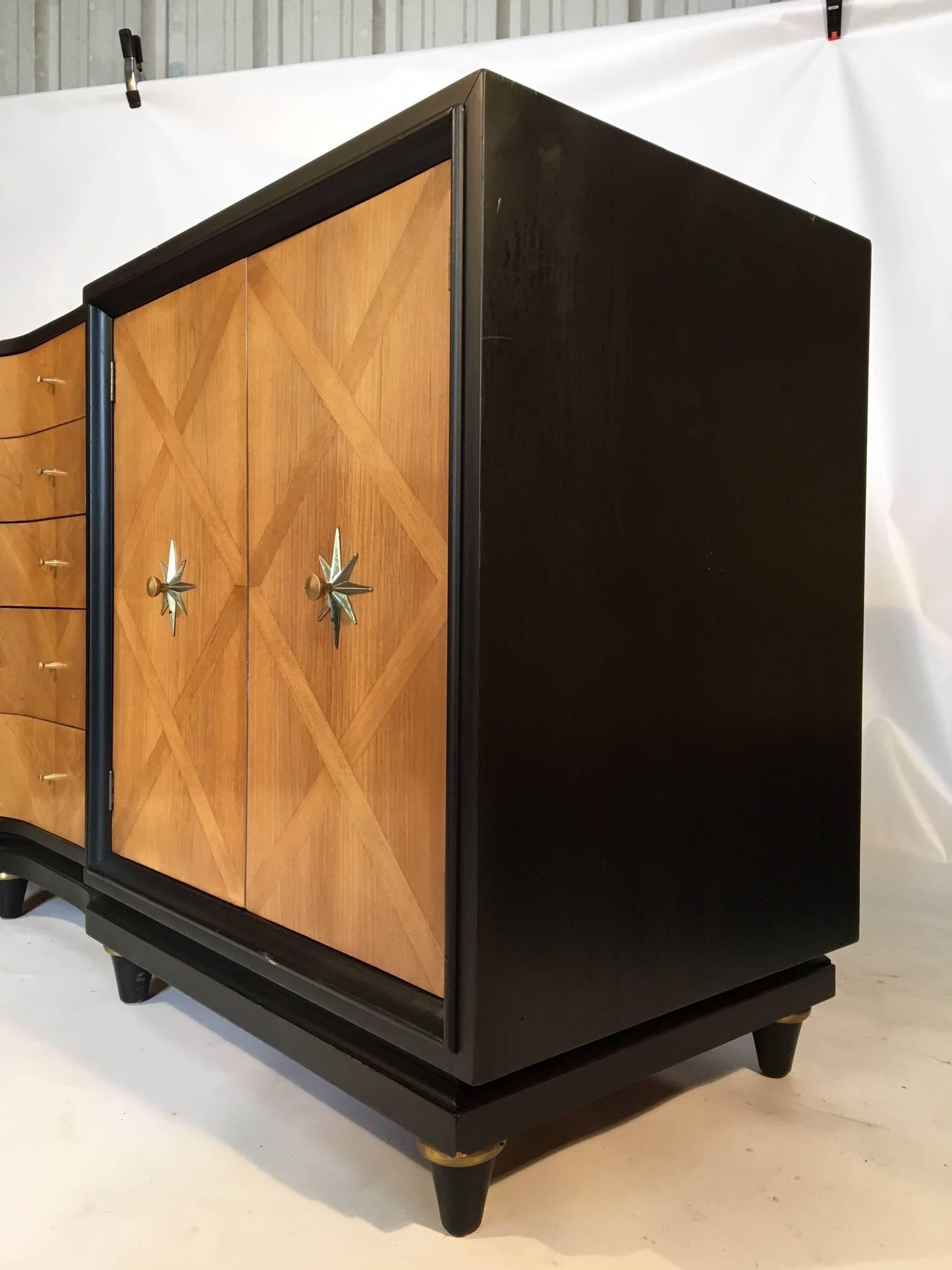 This midcentury dresser features beautiful wood inlay detailing and brass Art Deco style hardware. Centre section of five drawers with curved faces and two door sections reveal three drawers each. Excellent vintage condition with very minor age