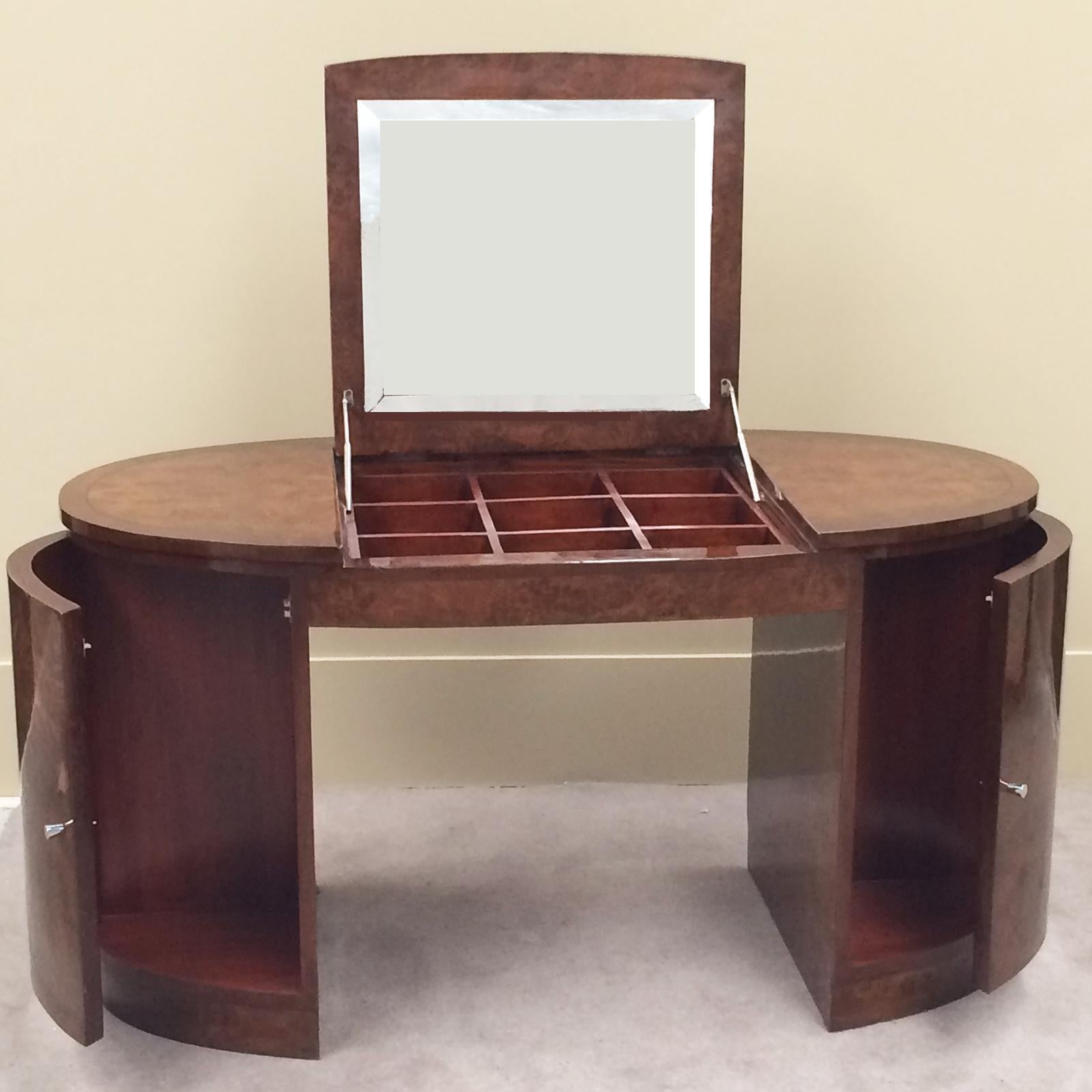 Art Deco style elliptical dressing table or would make an excellent desk, hidden mirror with compartments below. Mirror tilts up on nickel supports to open storage areas below, (9 divided compartments) in a mahogany tone, for Jewellery and/or