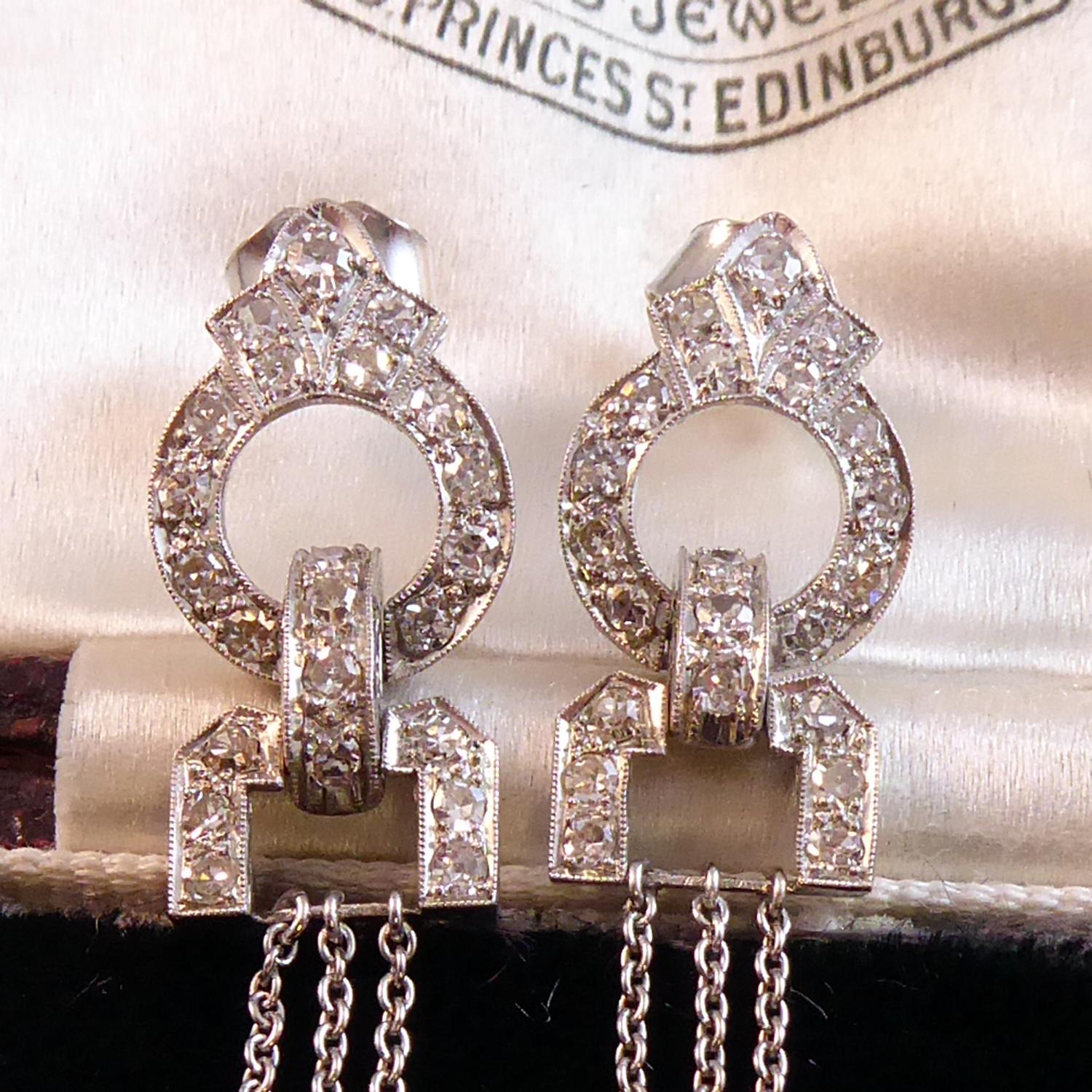 A conversion of an original Art Deco diamond set jewel into a pair of chandelier drop earrings entirely in keeping with the fashion of the 1920s.  Created for pierced ears the comprise a diamond set open circle featuring a three part fan-shaped