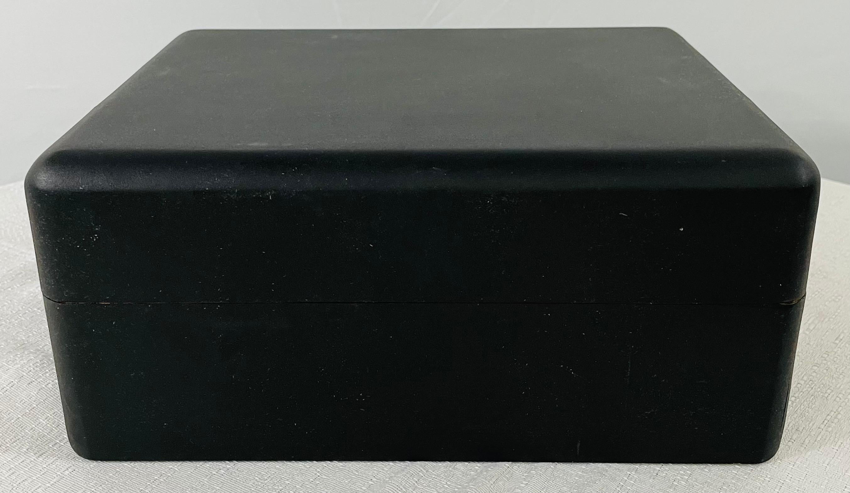 An Art Deco black Humidor or cigar box featuring a hygrometer and a humidifier inside. The black ebonized exterior is very elegant and sleek and the interior shows natural maple wood color. Made in Honduras, this elegant box will add style and