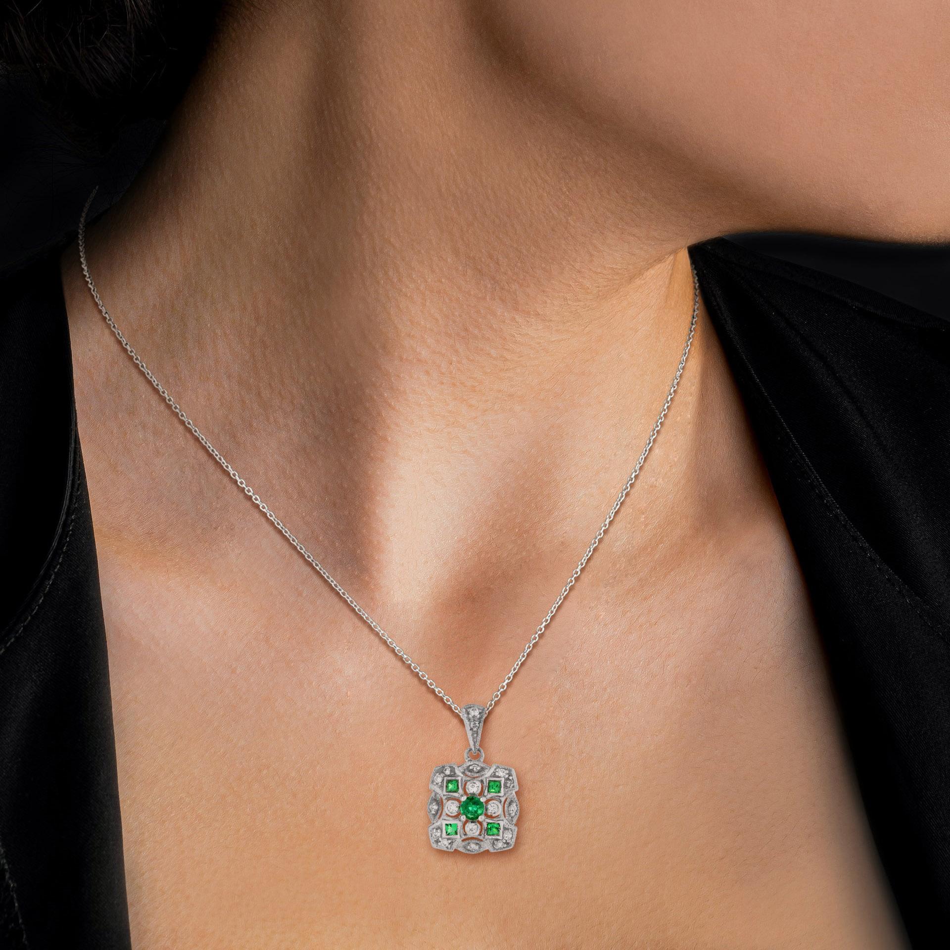 Art Deco style emerald and diamond square cluster pendant in 14k white gold. Centrally set with round emerald in prong setting, set to corners with emeralds in millgrain setting and further enhanced with round cut diamonds. 

Information
Metal: 14K