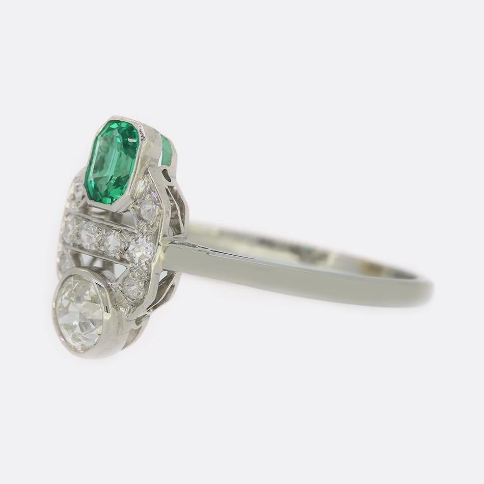 This is an Art Deco style emerald and diamond ring. The ring consists of one emerald cut emerald and a single old cut diamond in a typical Art Deco style setting which has been set with multiple smaller old cut diamonds. 

Condition: Used (Very