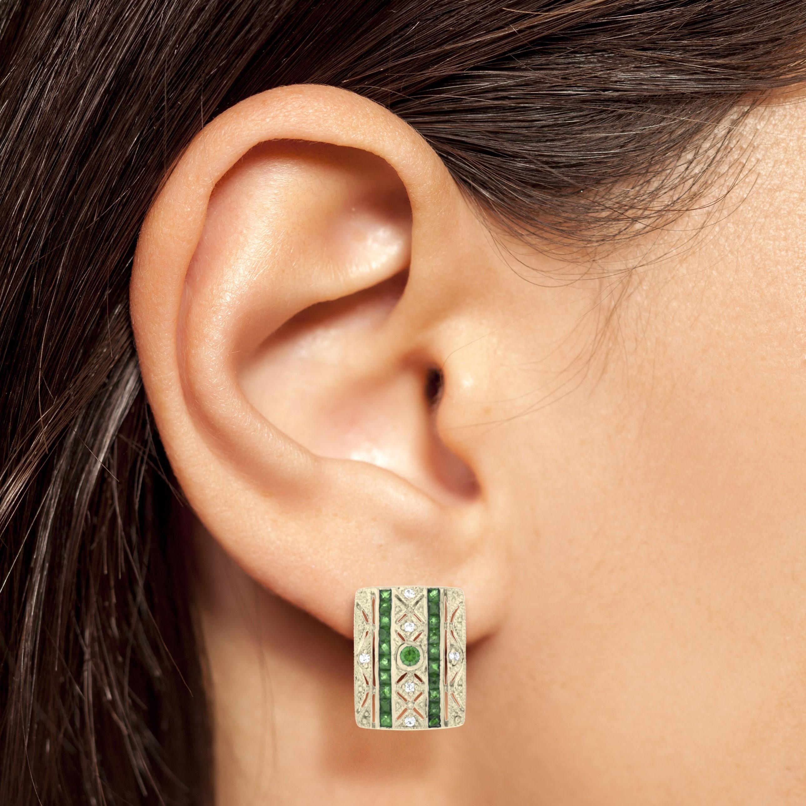 A beautiful pair of Art Deco style 14k yellow gold millgrain and open work square shape stud earrings featuring 2 round and 40 French cut emeralds with total of 0.06 carats diamonds. These simple and classic earrings are perfect to wear