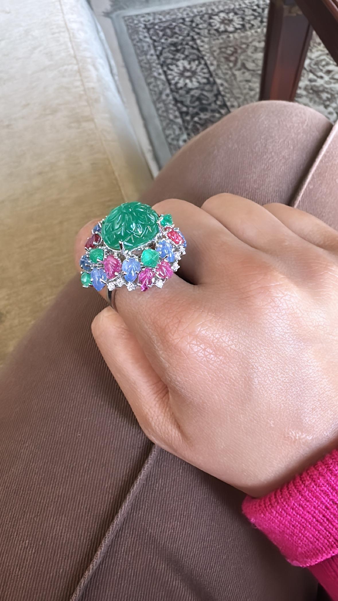 A very beautiful, Art deco style Emerald, Ruby & Blue Sapphire Tutti Frutti Cocktail Ring set in 18K Gold & Diamonds. The combined weight of the carved Emerald and sugarloaf cabochon  is 11.42 carats. The Emerald is completely natural, without any