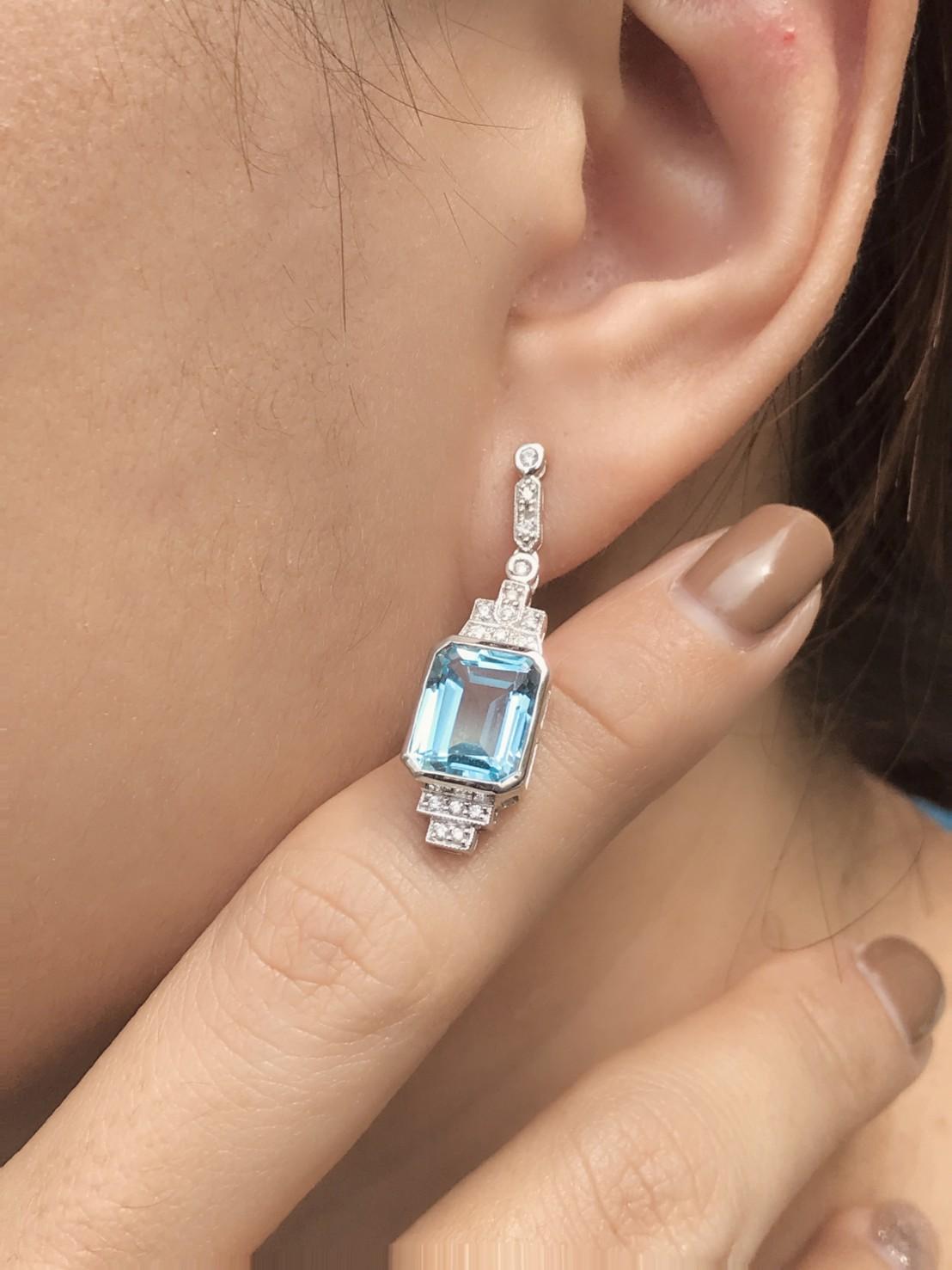 Express yourself with these insanely stylish, stunningly detail earrings with emerald cut blue topaz and diamonds in 9k white gold. Match them with your favorite outfit to complete your look. 

Information
Style: Art Deco
Metal: 9K White Gold
Width: