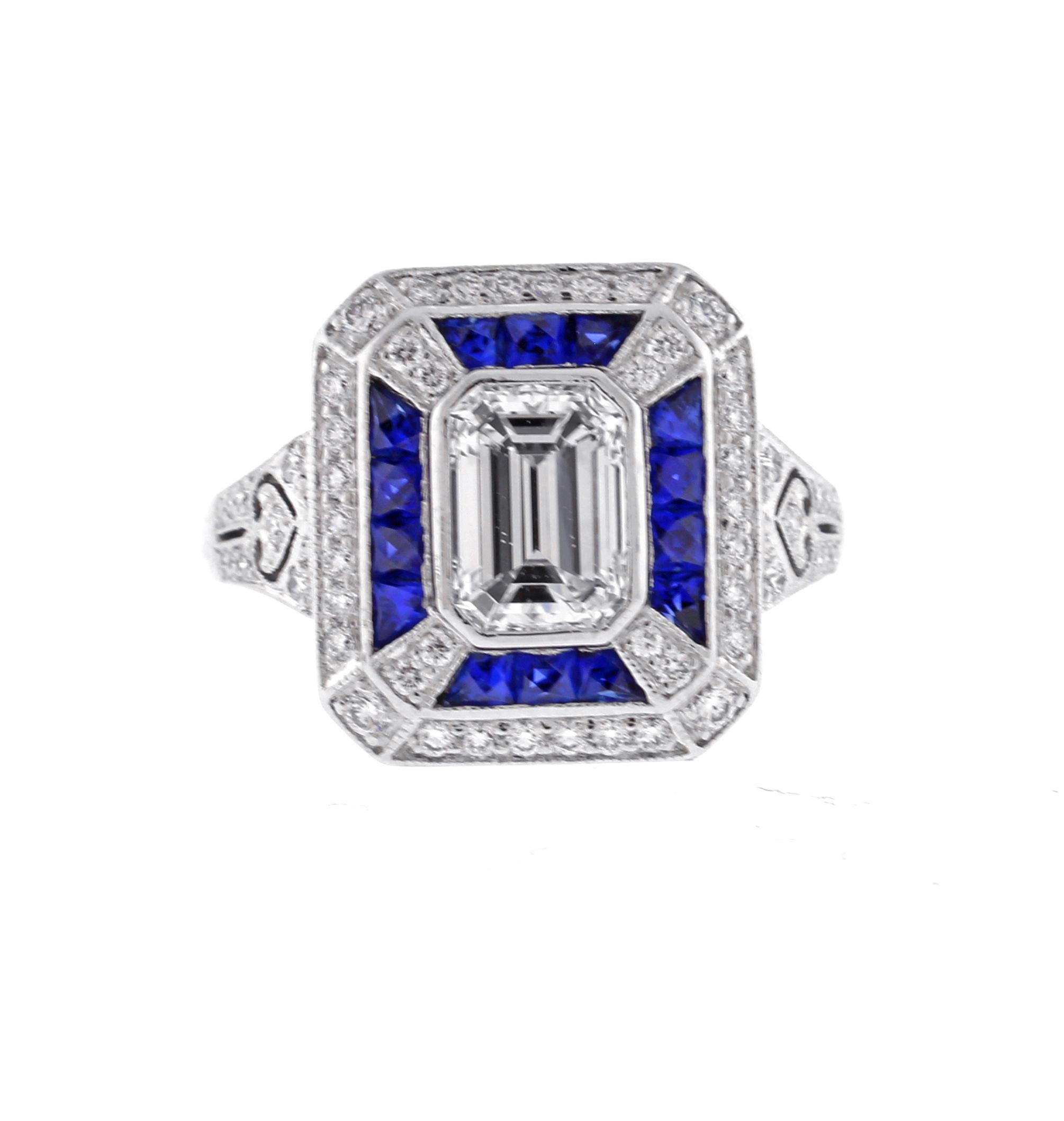 A wonderful emerald cut diamond and sapphire ring. The platinum meticulously crafted ring stays true to the art deco style with fine details and design
♦ Metal: platinum
♦ Circa 2010
♦ Emerald cut diamond  weighs approxemently 1.30 carats, I color