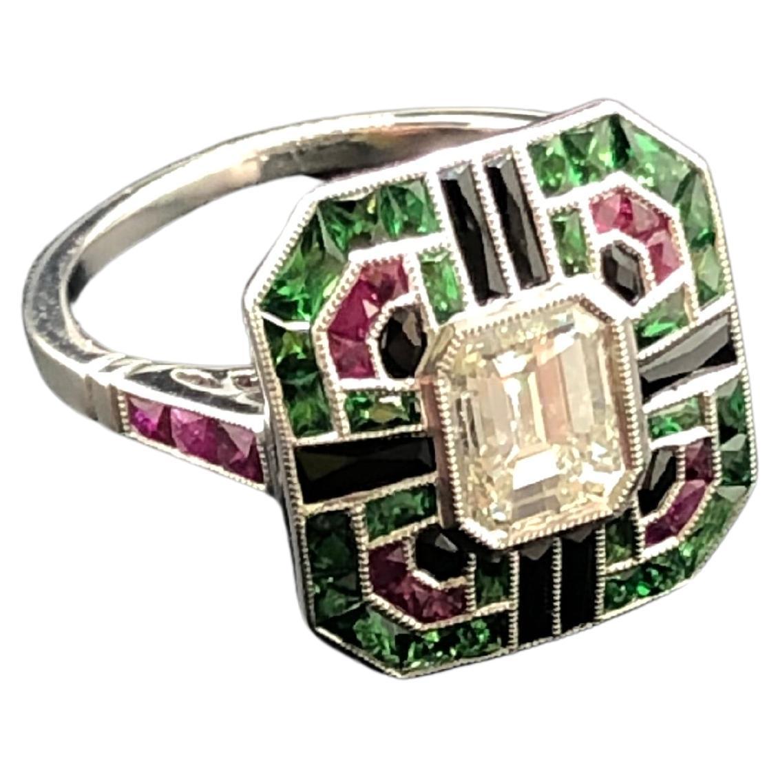 An Art Deco style cocktail ring featuring a single emerald-cut diamond weighing approximately 0.90 CTS, set in platinum within a frame of  French-cut tsavorite, ruby and black onyx gem-stones, with rubies to the shank, back of ring with intricate