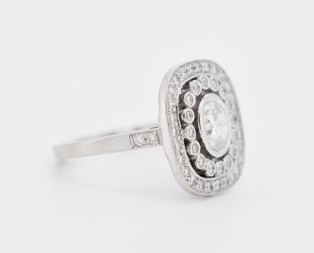 Stupendo anello di fidanzamento in stile Art Deco in platino. Presenta un diamante centrale rotondo taglio brillante di circa 0,6 carati, circondato da un doppio alone di diamanti rotondi taglio brillante per un totale di circa 0,8 carati. Le spalle
