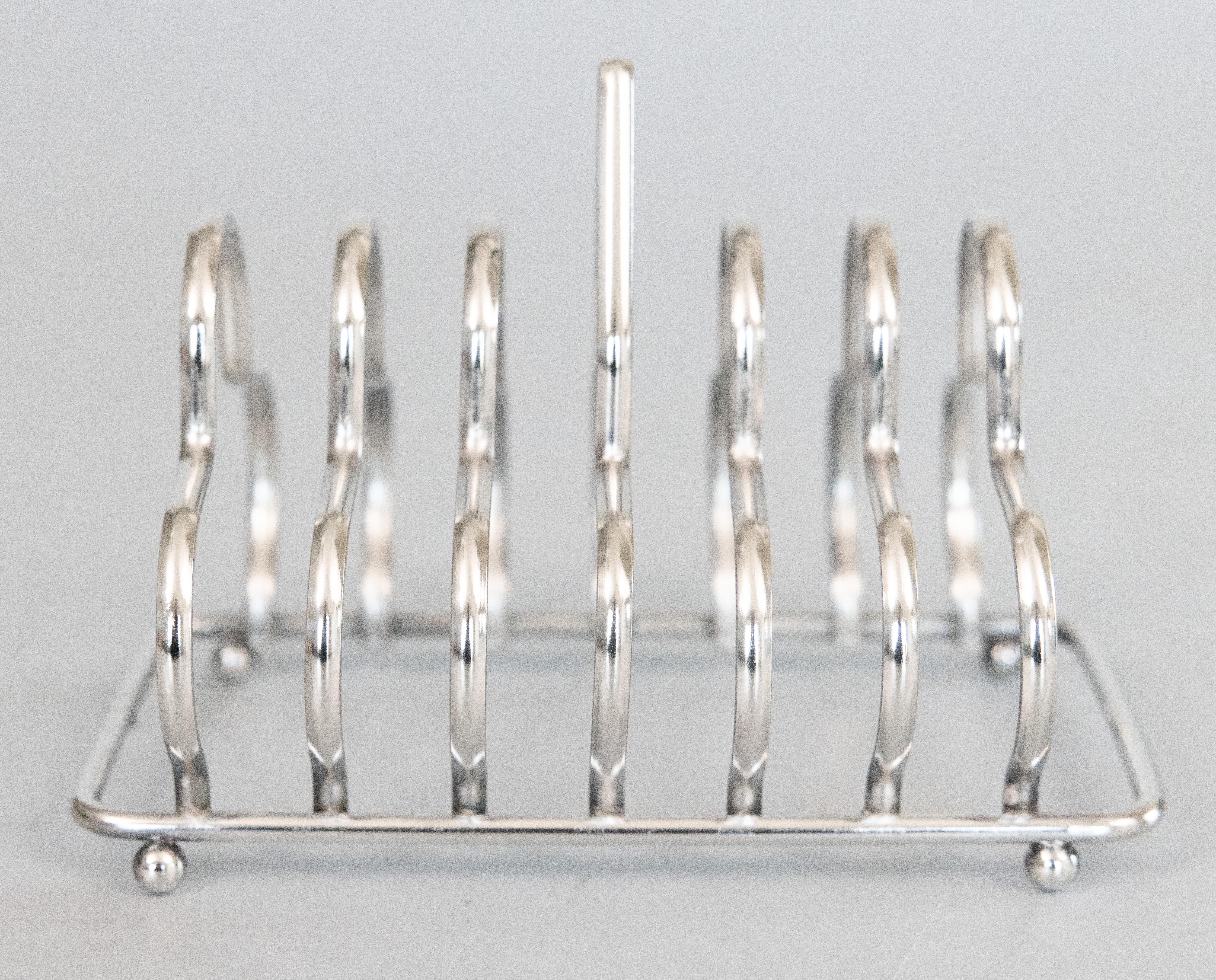 Un élégant porte-tartine vintage anglais en métal argenté à six tranches. Pas de marque de fabricant. Ce porte-tartines en argent de qualité supérieure est bien fabriqué et présente un ravissant motif trilobé de style Art déco ainsi que de charmants