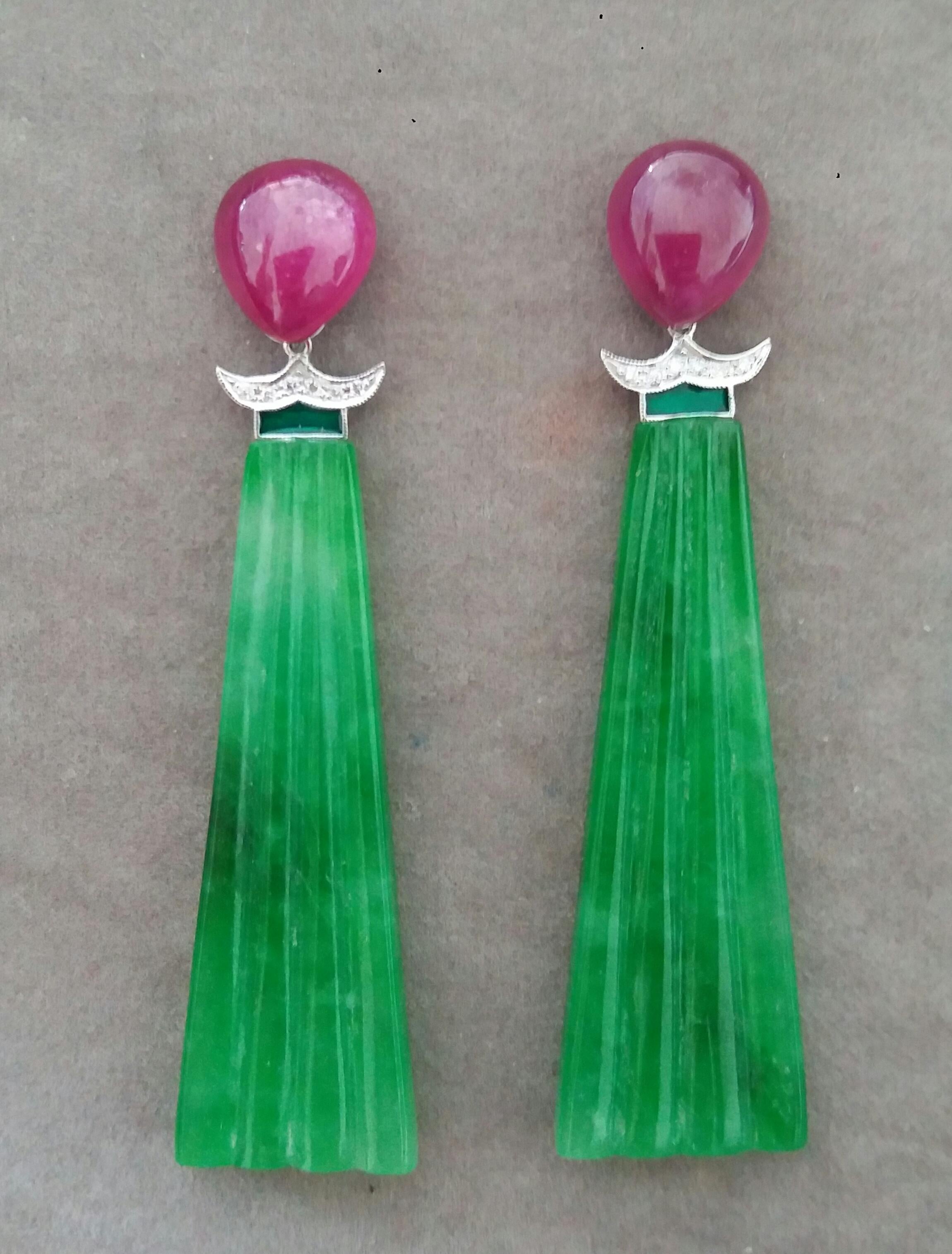 The tops are 2 Ruby OvalPear Shape cabs measuring 10x12 mm ,middle parts are composed of 2 white gold elements with 14 round full cut diamonds and Green Enamel ,in the bottom parts we have 2 Engraved Jades 54 mm long and 14 mm wide.

In 1978 our