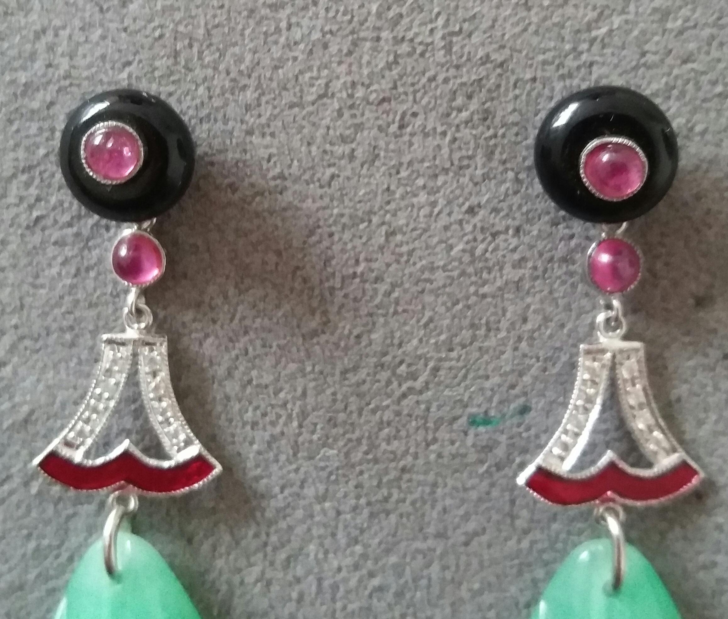 A pair of elegant  classic Art Deco style earrings, with an upper part consisting of 2 black onyx buttons with in the center 2 small round ruby cabochons, in the central part where we have 2 elements in white gold, diamonds and red enamel,that