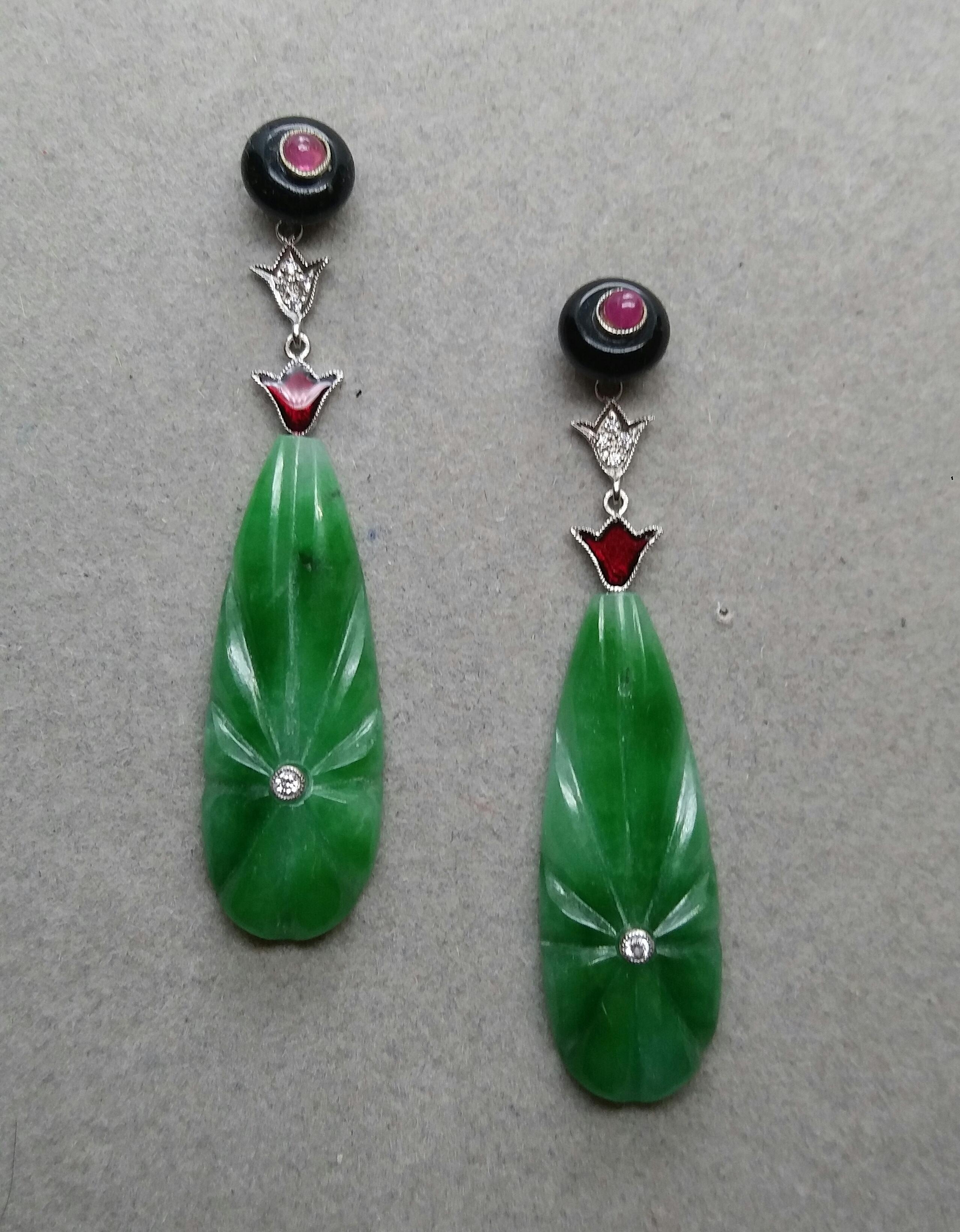  A pair of elegant  classic Art Deco style earrings, with an upper part consisting of 2 black onyx buttons with in the center 2 small round ruby cabochons, in the central part where we have 2 elements in white gold, diamonds and red enamel,that