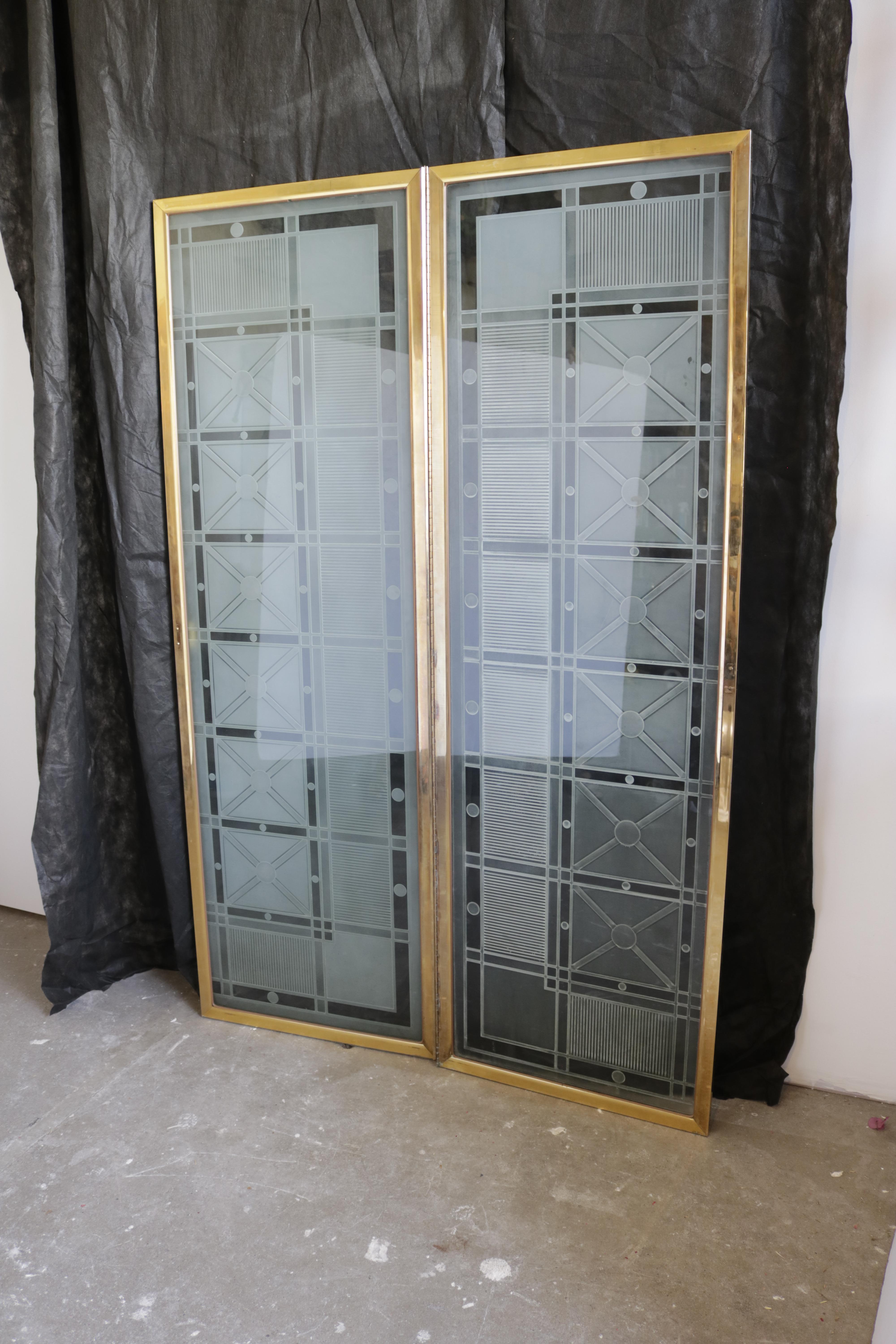 Finely molded plexiglass 2-fold screen in the Art Deco style, with brass frame. Each fold features a small brass handle.