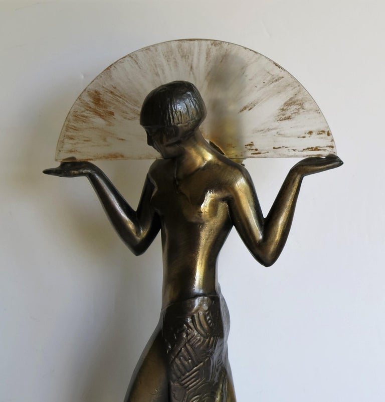 This is a stunning, tall, figurine table lamp of a Fan Dancer, modelled after a Max Le-Verrier original, who was a famous French Sculptor, based in Paris.

The figurine is made of a bronzed cast metal, with some dark gun metal grey hand painted
