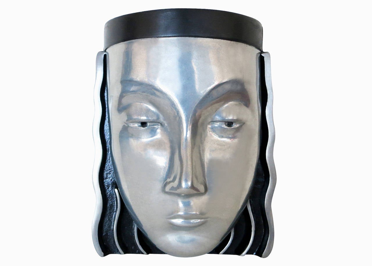 A pair of Art Deco styled female face mask wall sconces with a signature on the back marked“118 P.