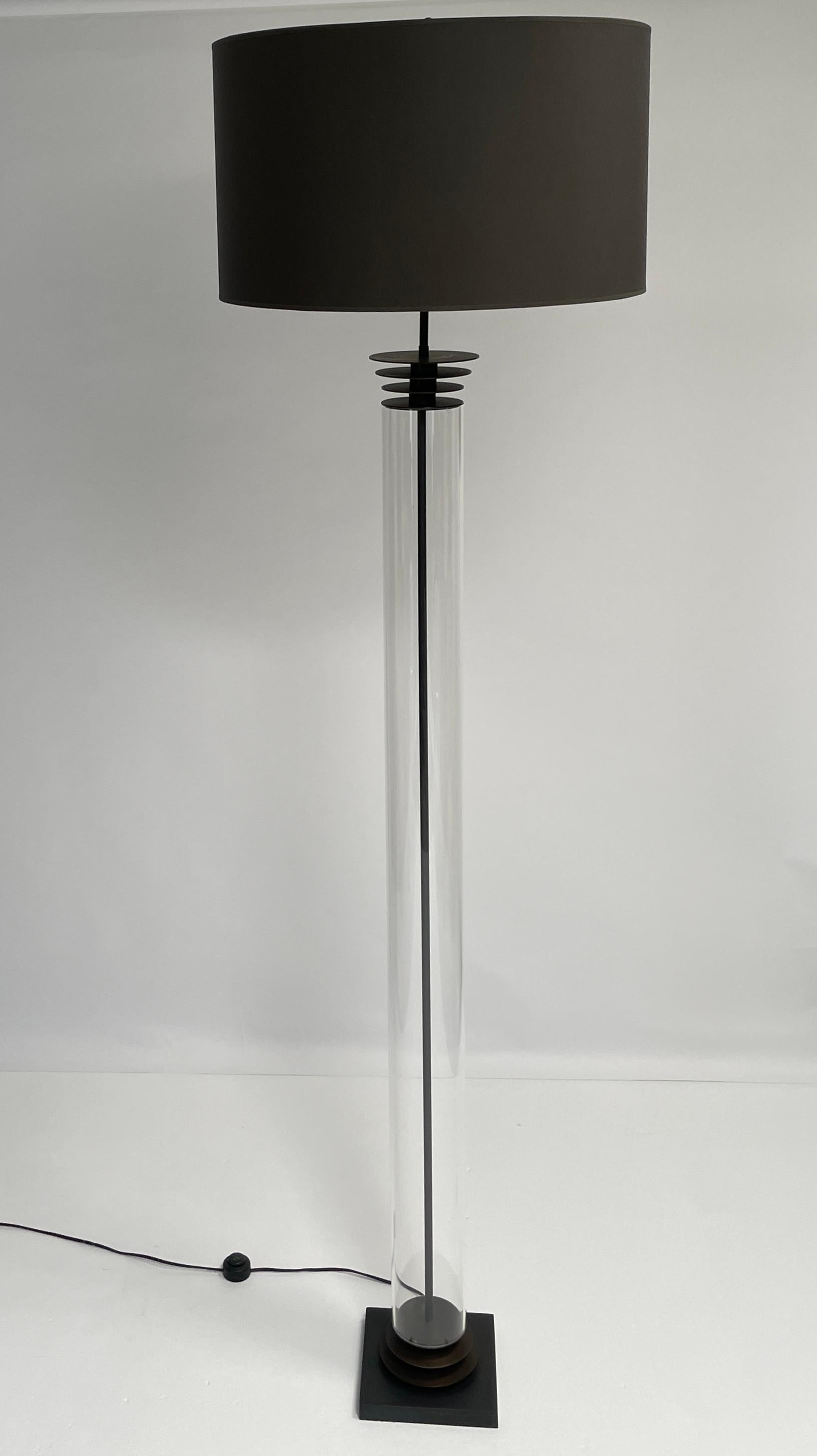 Large-Scale Art Deco Floor Lamp This striking floor lamp brings bold 1940s Art Deco elegance to any space. Its sculptural silhouette is defined by a grand glass tube body, capped with three sleek discs, all adorned in a rich oil-rubbed bronze patina