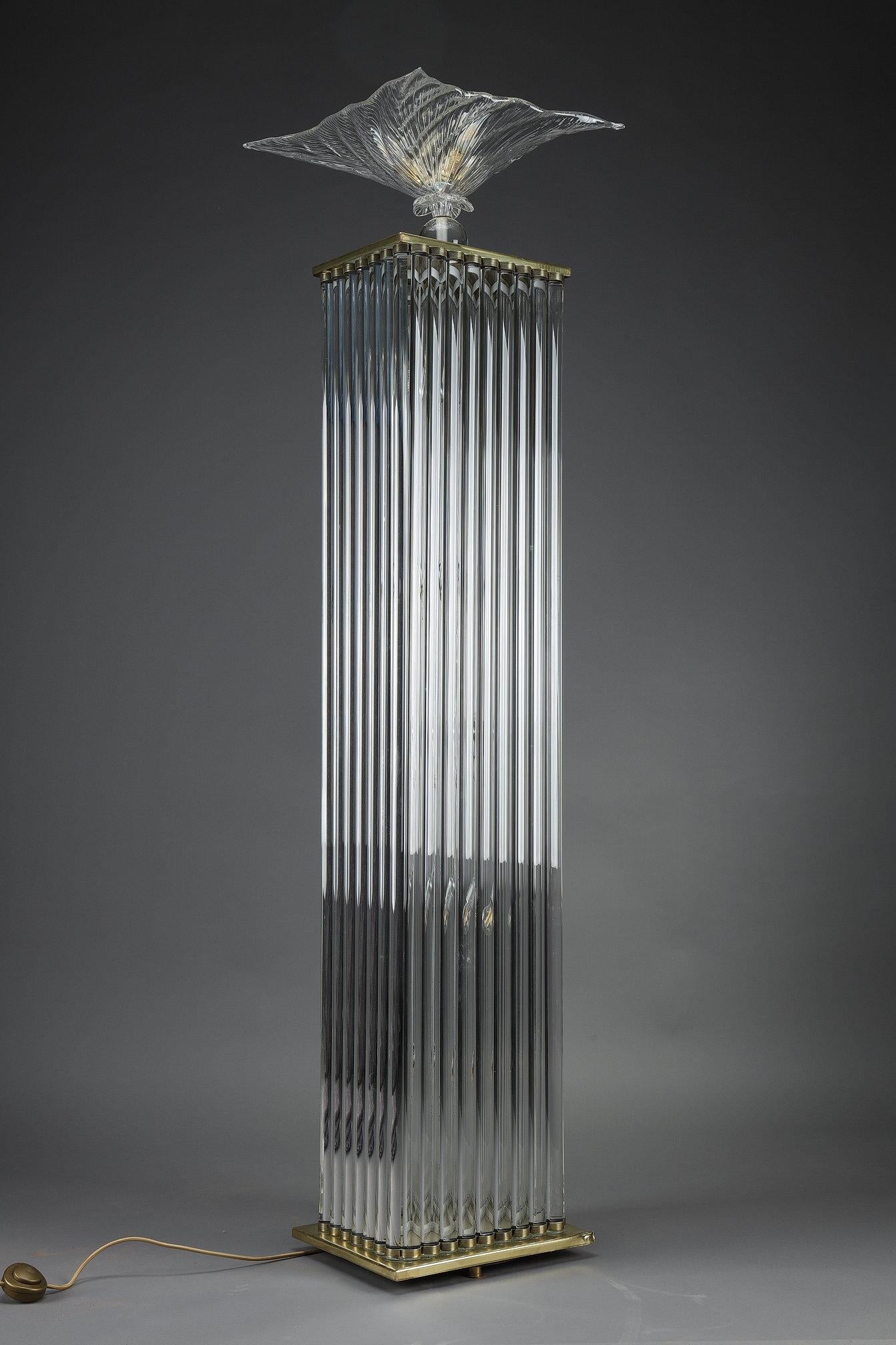 Floor lamp forming a column whose body is made up of glass tubes set on a brass base and topped by a glass shade forming a flowery basin. The fixture is electrified, with bulbs both inside the column and in the bowl. This typically Art Deco-style