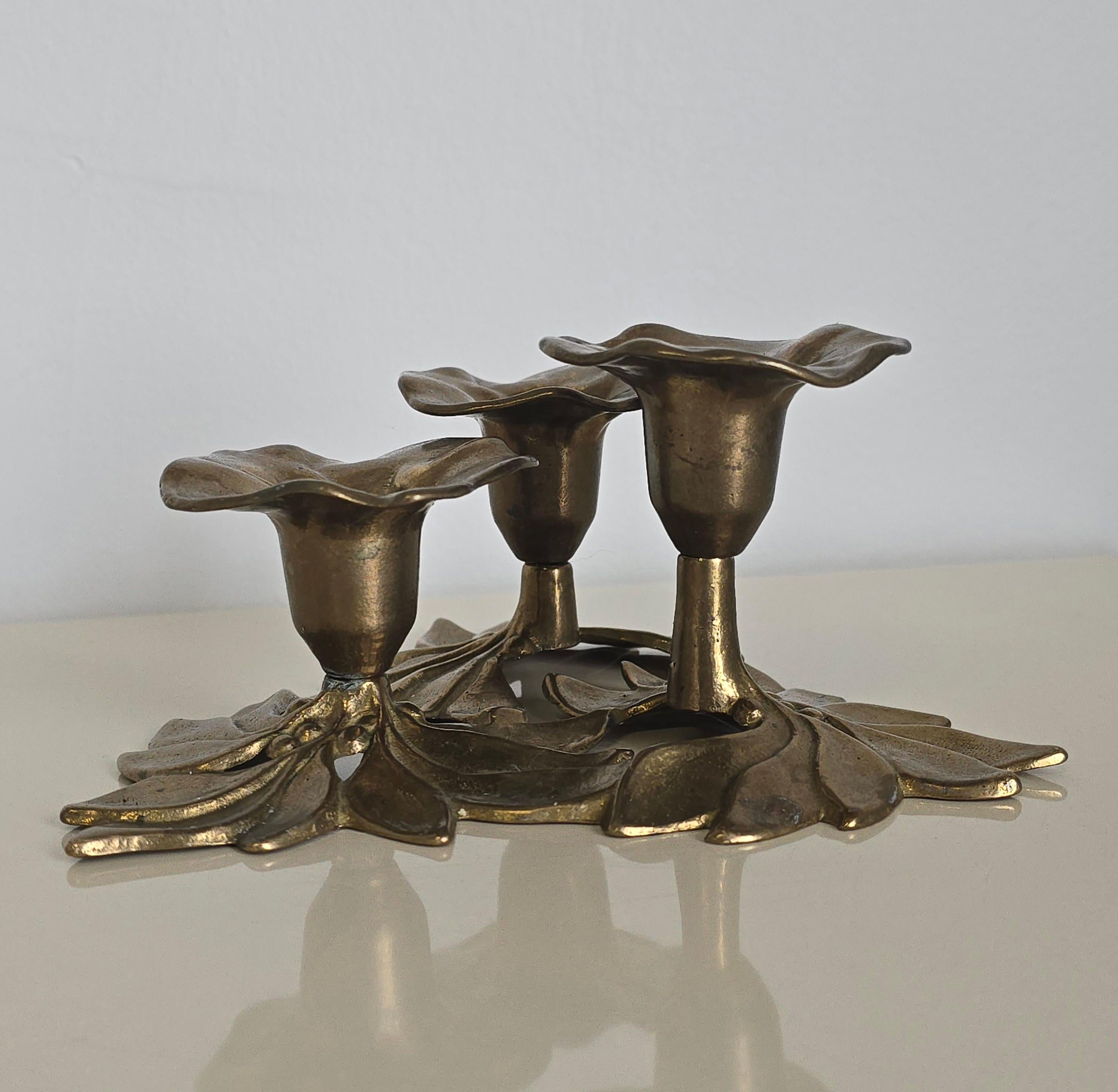 Splendido candelabro floreale in stile Art Déco. Questo candelabro è realizzato in ottone e ha tre supporti di diverse altezze. Il candelabro ha un aspetto floreale: i supporti sono fiori e le basi sono foglie. Nel complesso è in buone condizioni