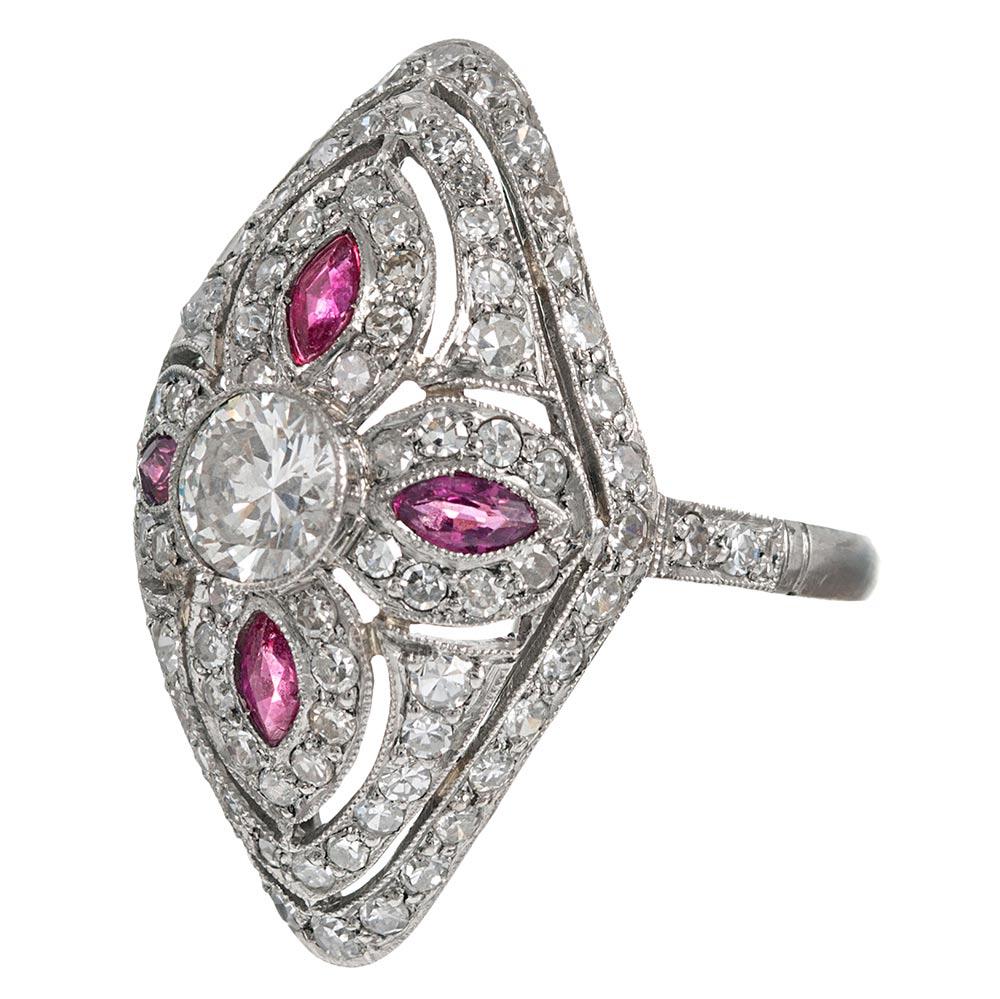 The design of this ring is inspired by the classic creations from the Art Deco period, yet the piece is of newer manufacture. Hand made in platinum, the design is centered upon a four-leaf clover of white diamonds with marquis rubies anchored by a