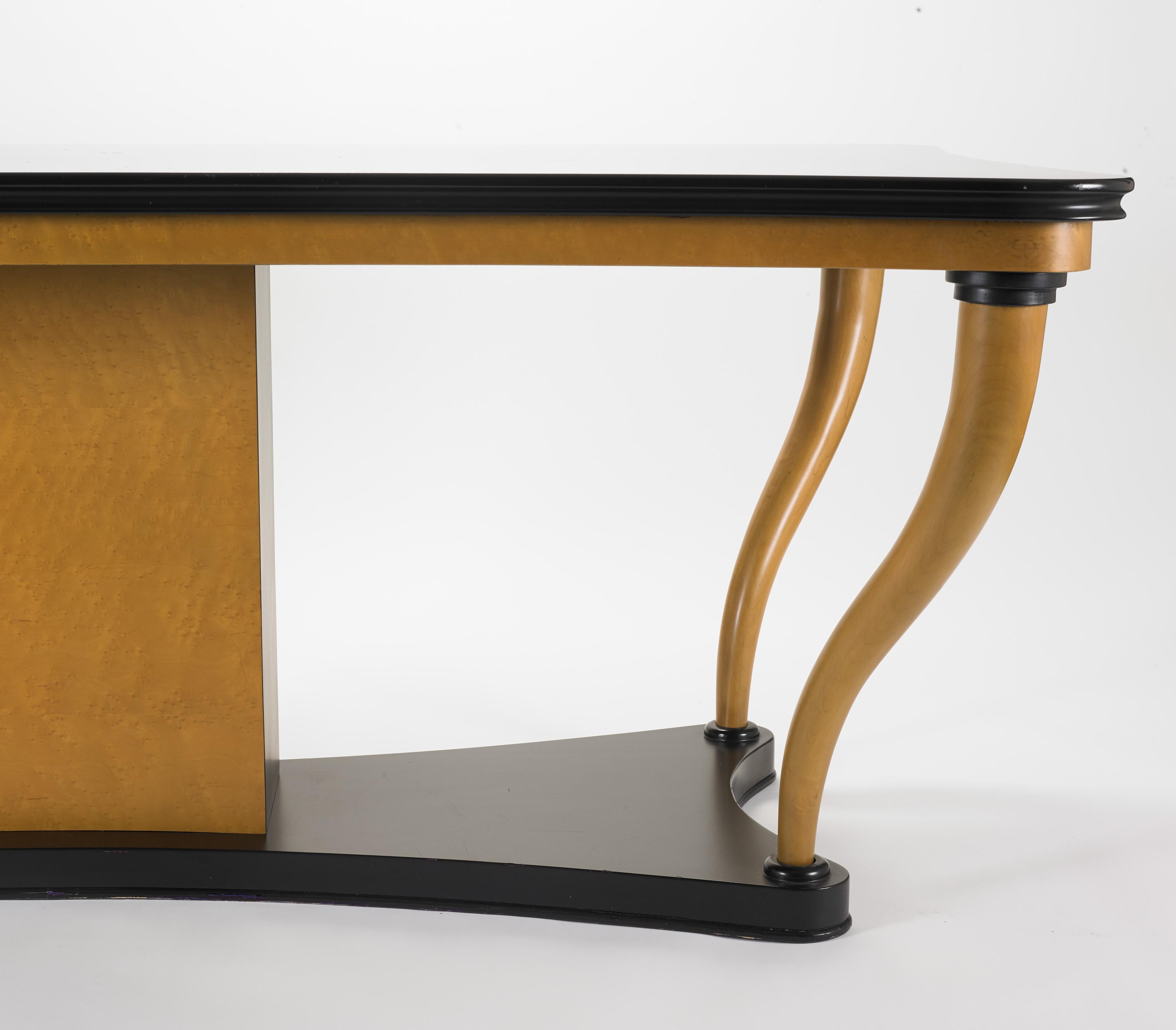 Offered is an Art Deco style rectangular-shaped polished Bird's Eye Maple wood and black matte lacquer table that is versatile in nature as it can be used as a console, a desk, a center foyer or hallway table, or as a small conference or library