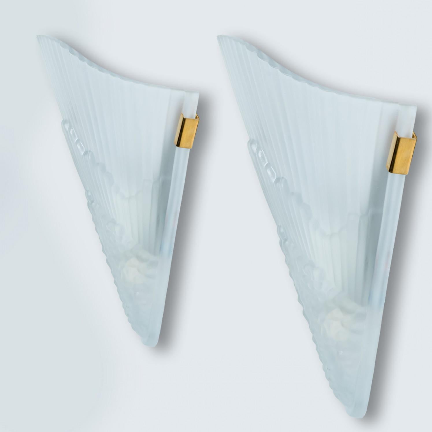 Art Deco style brass and frosted glass wall lights.  Manufactured in Italy around 1970.
With their clean modernist lines and beautiful attention to detail, these sconces would be a winning addition to any style of interior from classical decoration