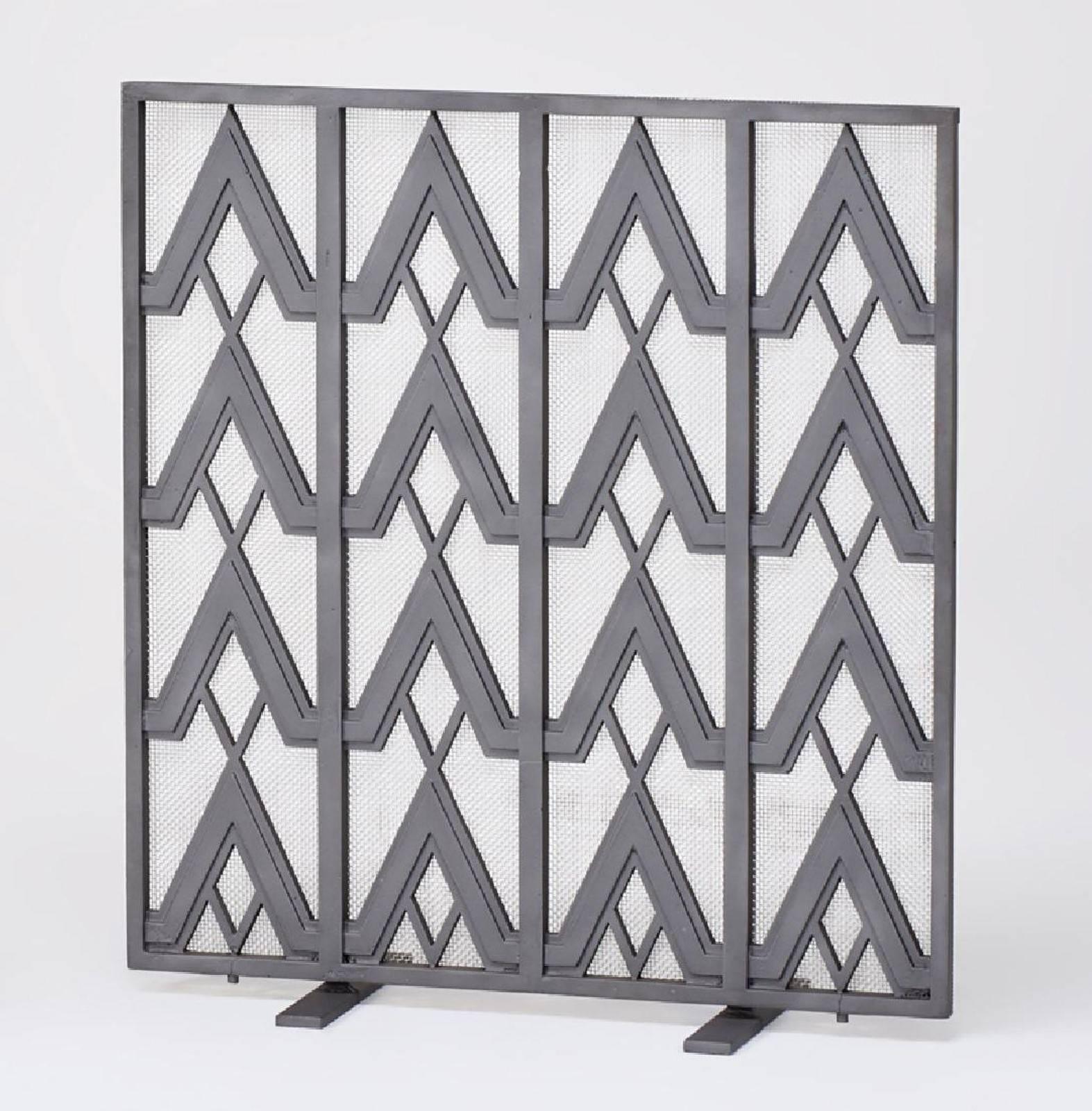 A forged iron Art Deco style fire screen featuring highly graphic geometric details overall.
The flat front panel depicting triangular shaped designs intersected by vertical stripes creating a functional .web of eye pleasing patterns
The iron is
