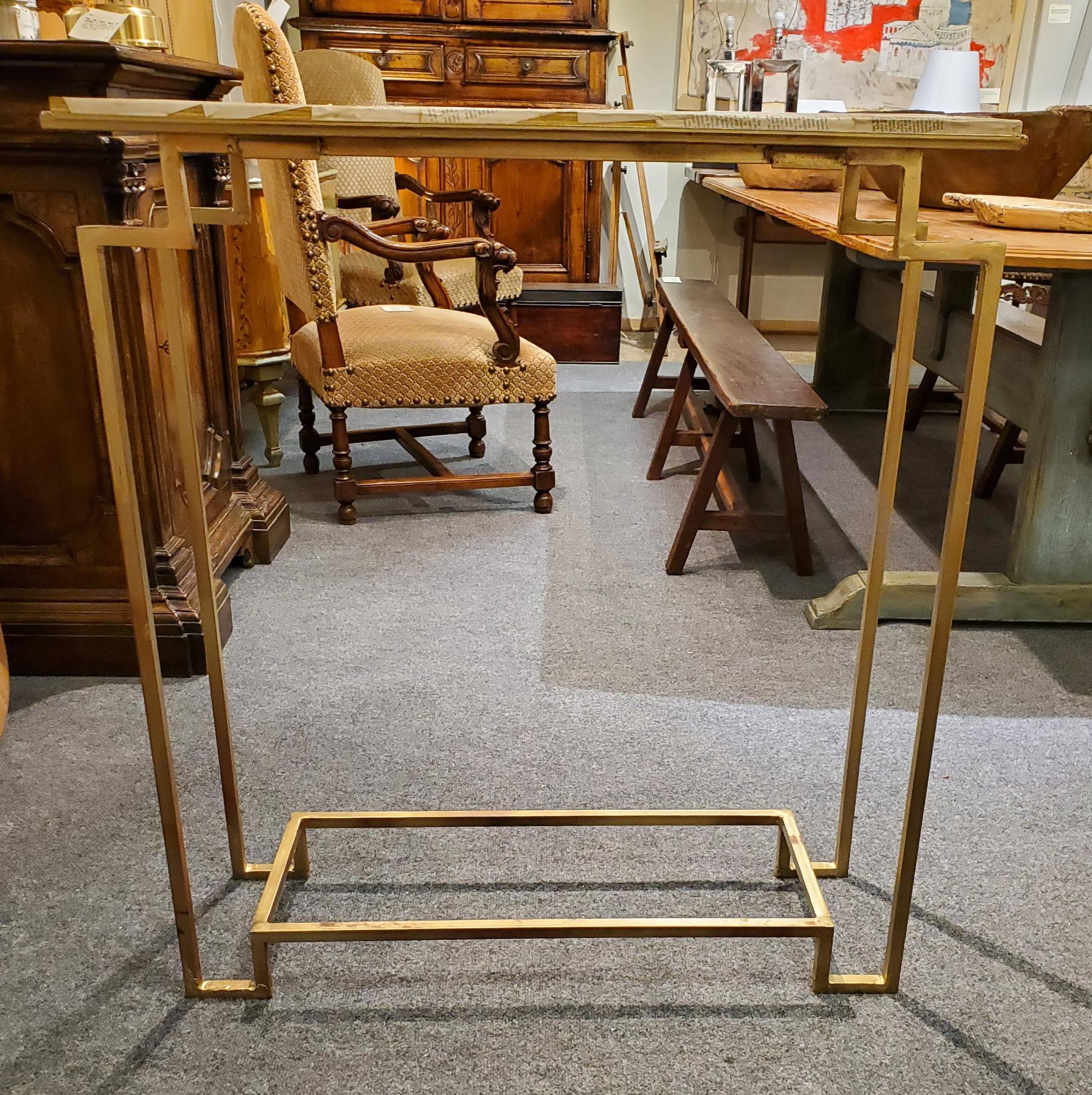 Art Deco style Gilt Metal “Apollo” console table. Excellent proportions, very architectural with a “distressed antique” gilt finish to the metal. Decoupaged with pages of the Classic book 