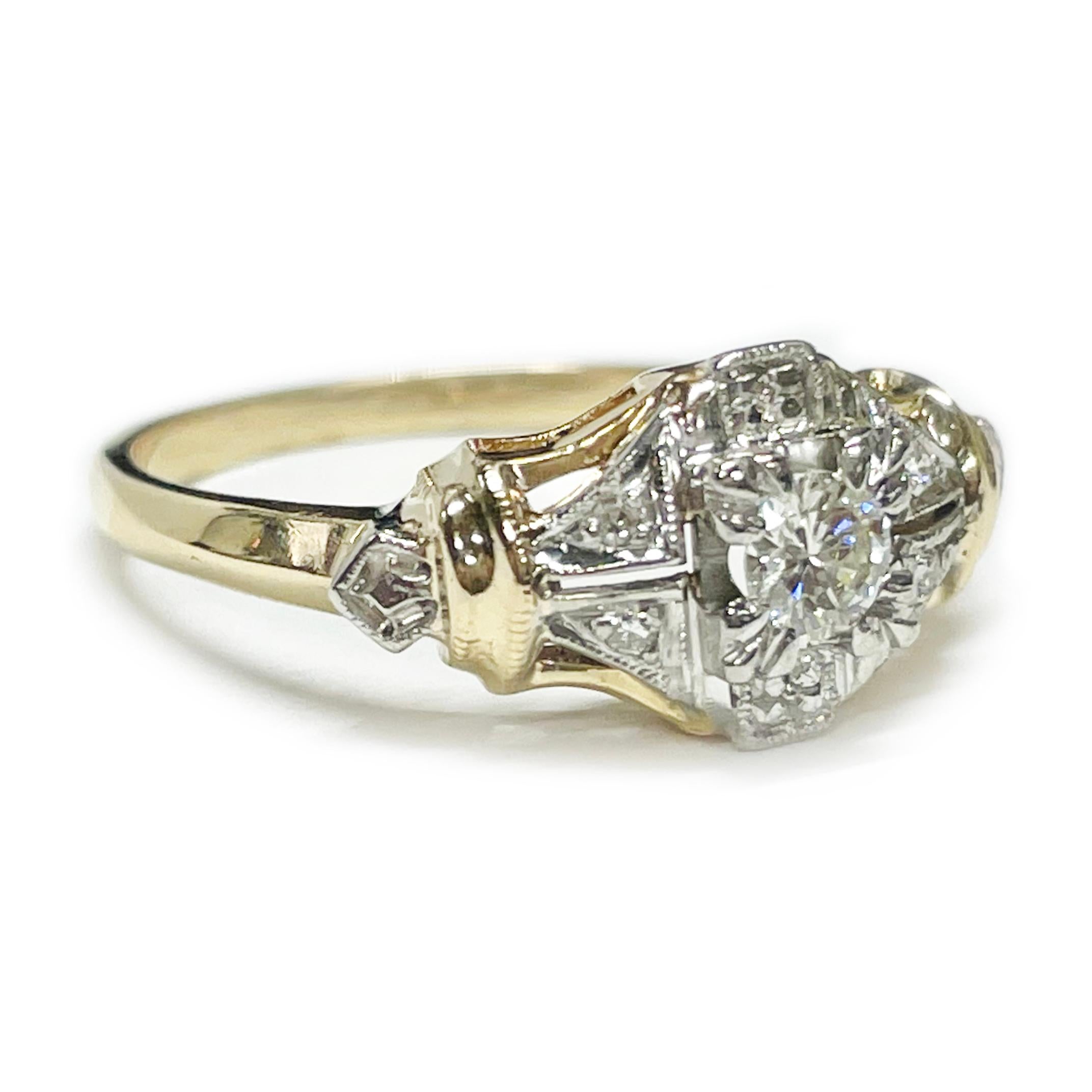 Art Deco Stil (Replik) Gelb- und Weißgold Diamantring. In der Mitte des Rings befindet sich ein runder Diamant im Brillantschliff mit einer Größe von 3 mm. Außerdem gibt es vier runde Nahkampfdiamanten und einige diamantgeschliffene Fassungen. Die