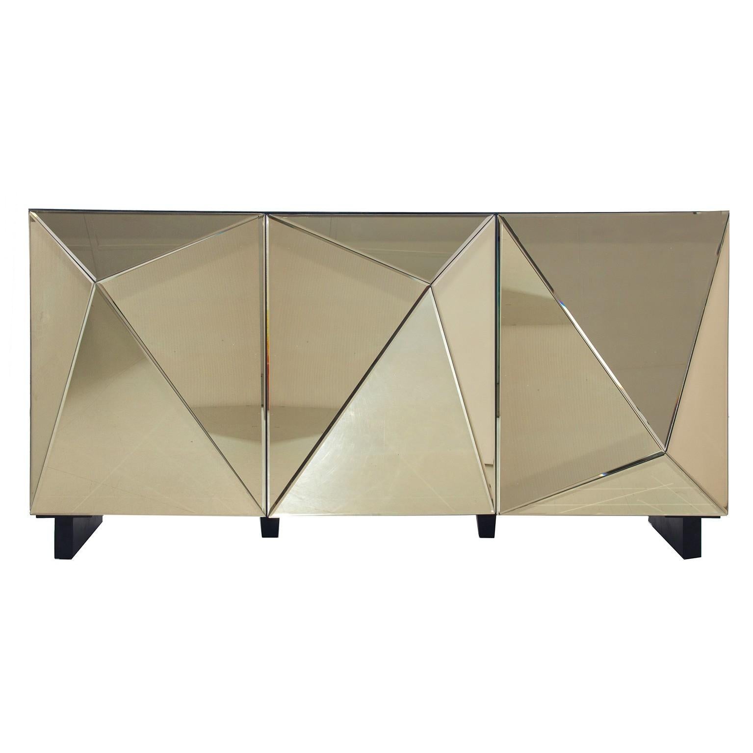 Sparkling and sophisticated gold mirror sideboard with black wooden feet and three mirrored doors diamond shaped open on shelves.