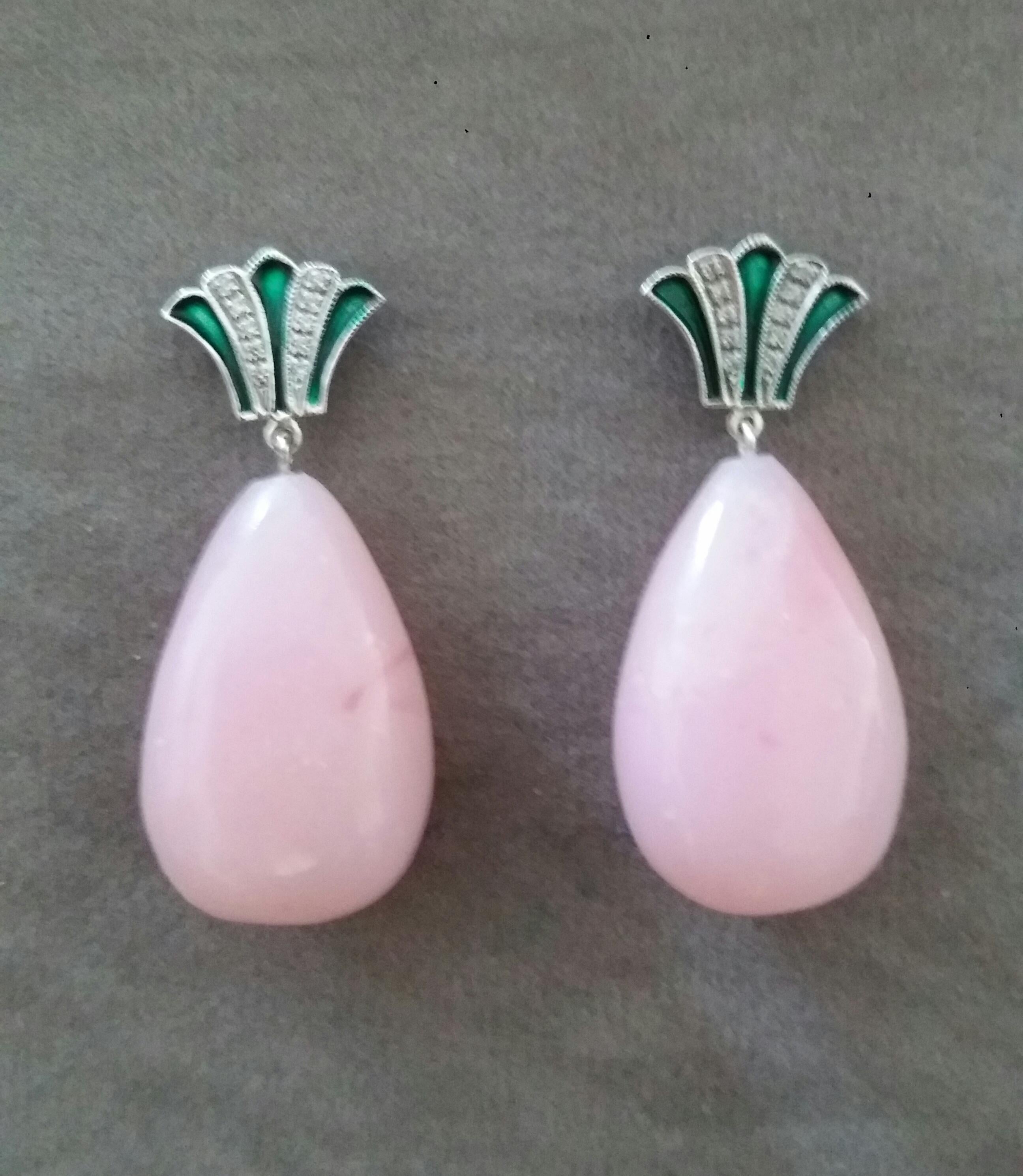 In these classic Art Deco Style earrings the tops are 2 crown shape elements  in 14 kt.white gold, 20 round full cut diamonds and green enamel ,in the lower parts we have  2 Pink Opal Round Drops measuring 16mm x 25mm

In 1978 our workshop started