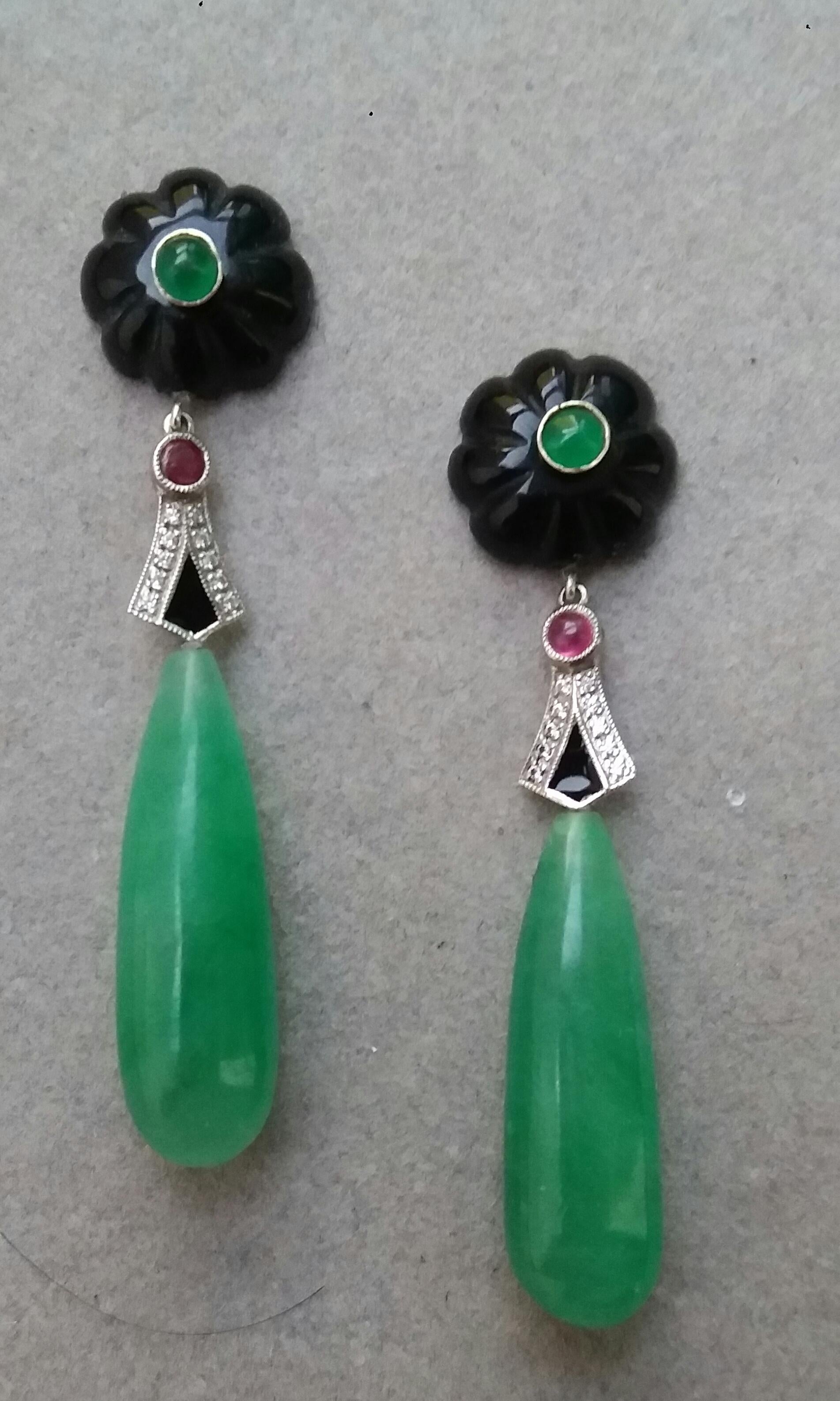 In these classic Art Deco Style earrings the tops are 14 mm round carved black onyx buttons with small emeralds round cabs in the center,middle parts are in white gold, 20 round full cut diamonds,small round ruby cabs,in the lower partes we have 2