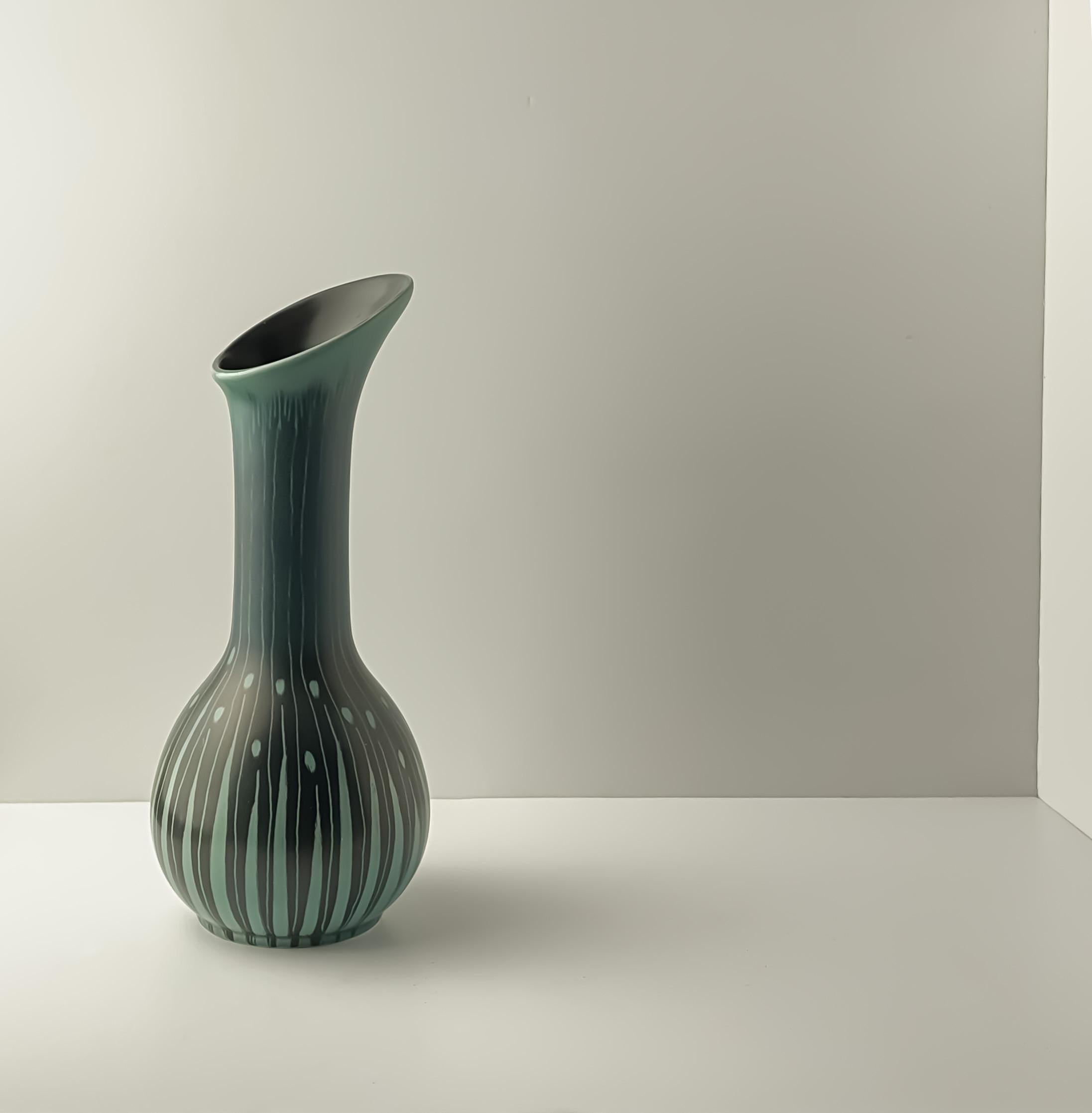 Questo vaso in ceramica in stile Art Déco, disegnato da Colin Melbourne e prodotto da Beswick, in Inghilterra, presenta un sorprendente smalto turchese e nero con audaci strisce organiche. La sua forma scultorea, ispirata alla calla, presenta un